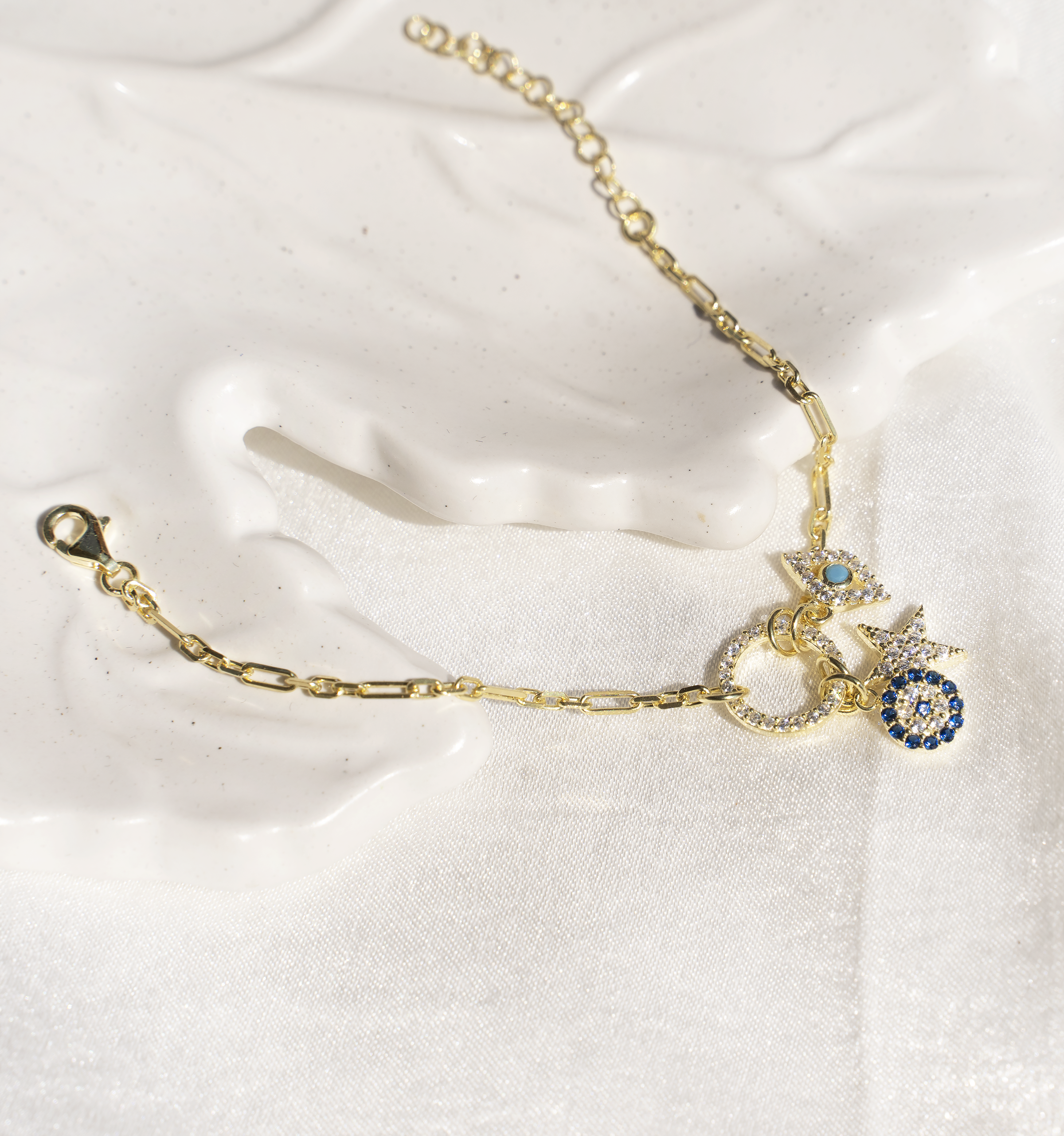 PARISA Charm Bracelet featuring three unique charms: a royal blue medallion, an evil eye, and a glittering star, crafted from 925 Sterling Silver with yellow gold plating.