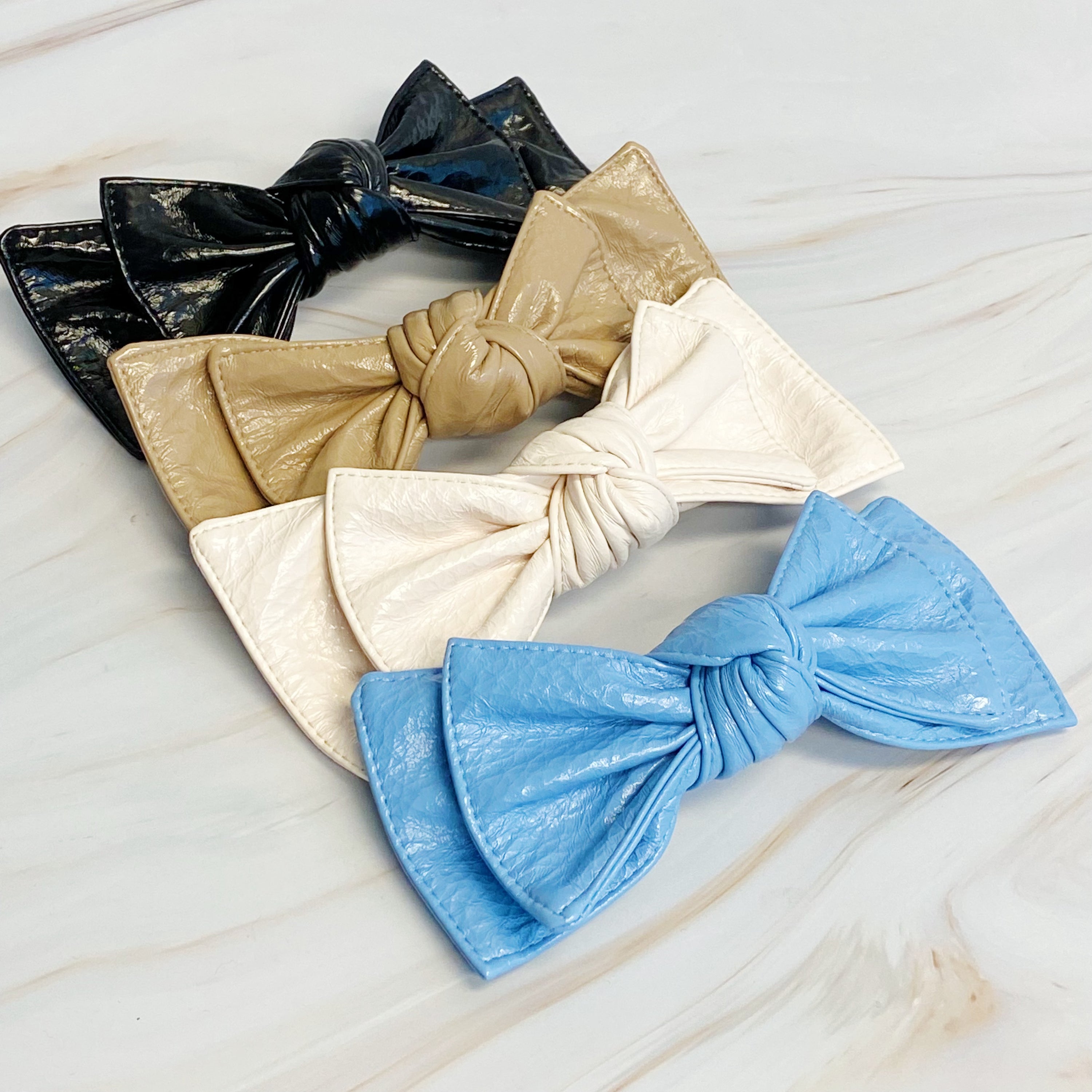 Patent Double Bow Hair Clip in faux patent leather, featuring a stylish double bow design, perfect for various hairstyles.