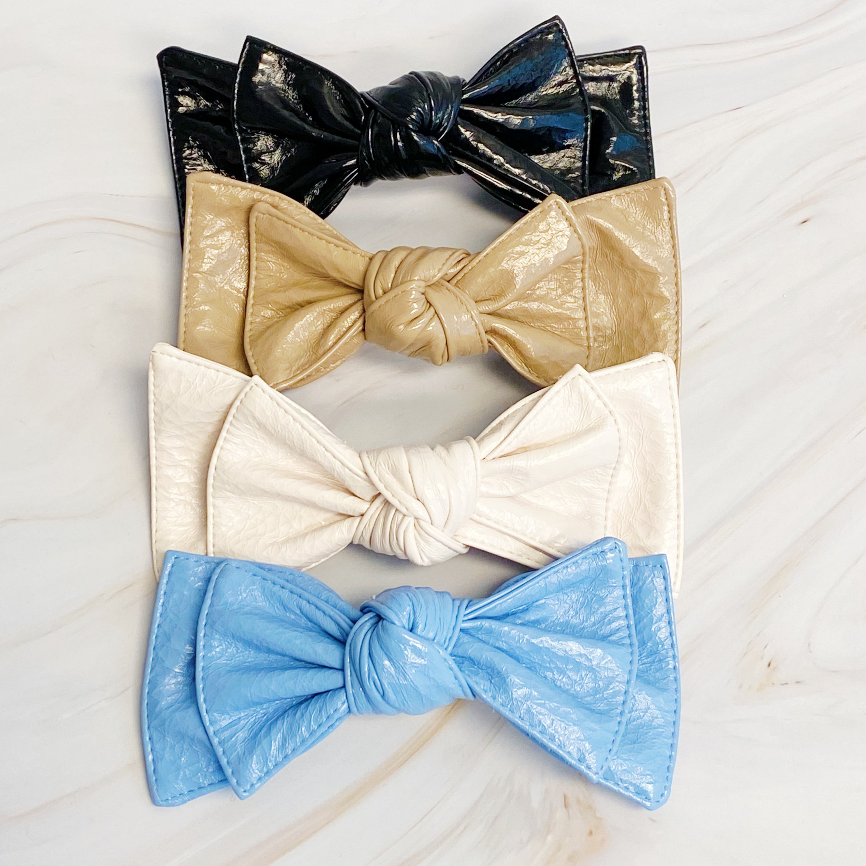 Patent Double Bow Hair Clip in faux patent leather, featuring a stylish double bow design, perfect for various hairstyles.