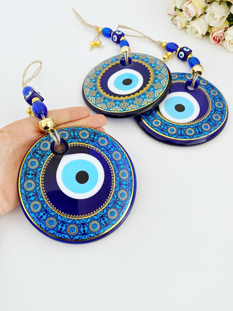 A beautifully crafted 13cm patterned Evil Eye wall hanging featuring vibrant blue hues and intricate designs, symbolizing protection and good fortune.