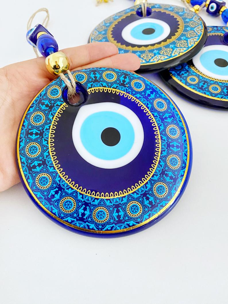 A beautifully crafted 13cm patterned Evil Eye wall hanging featuring vibrant blue hues and intricate designs, symbolizing protection and good fortune.