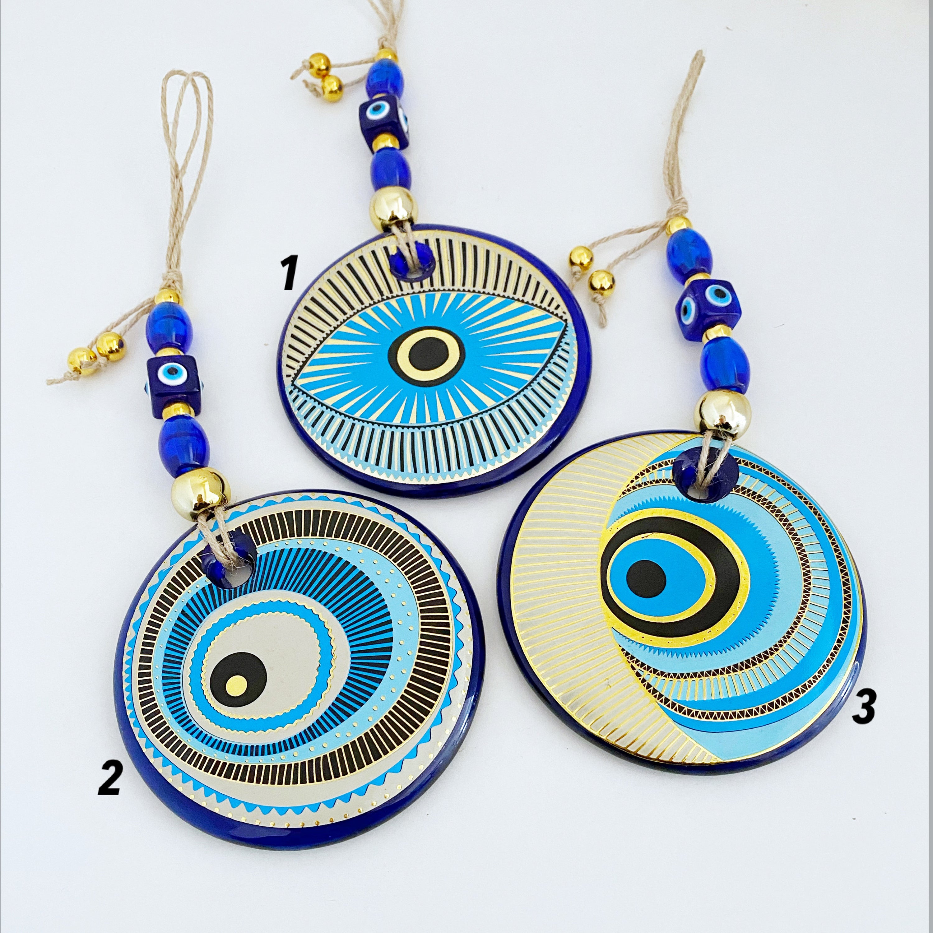 A beautifully painted blue evil eye wall hanging featuring intricate patterns, perfect for home decor and protection.