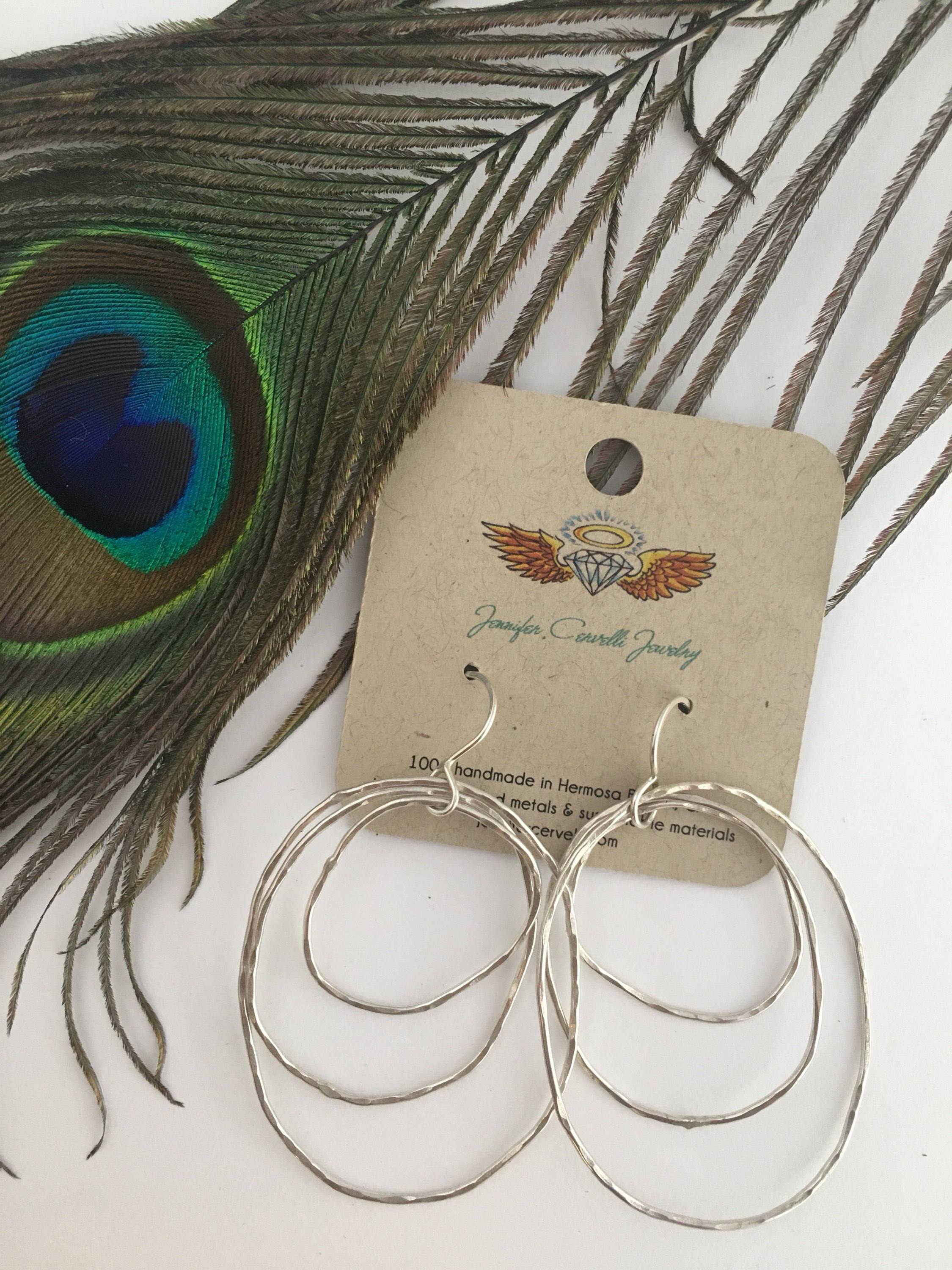 Handmade Peacock Feather Earrings featuring intricate designs inspired by nature, crafted from recycled metals in Hermosa Beach, California.