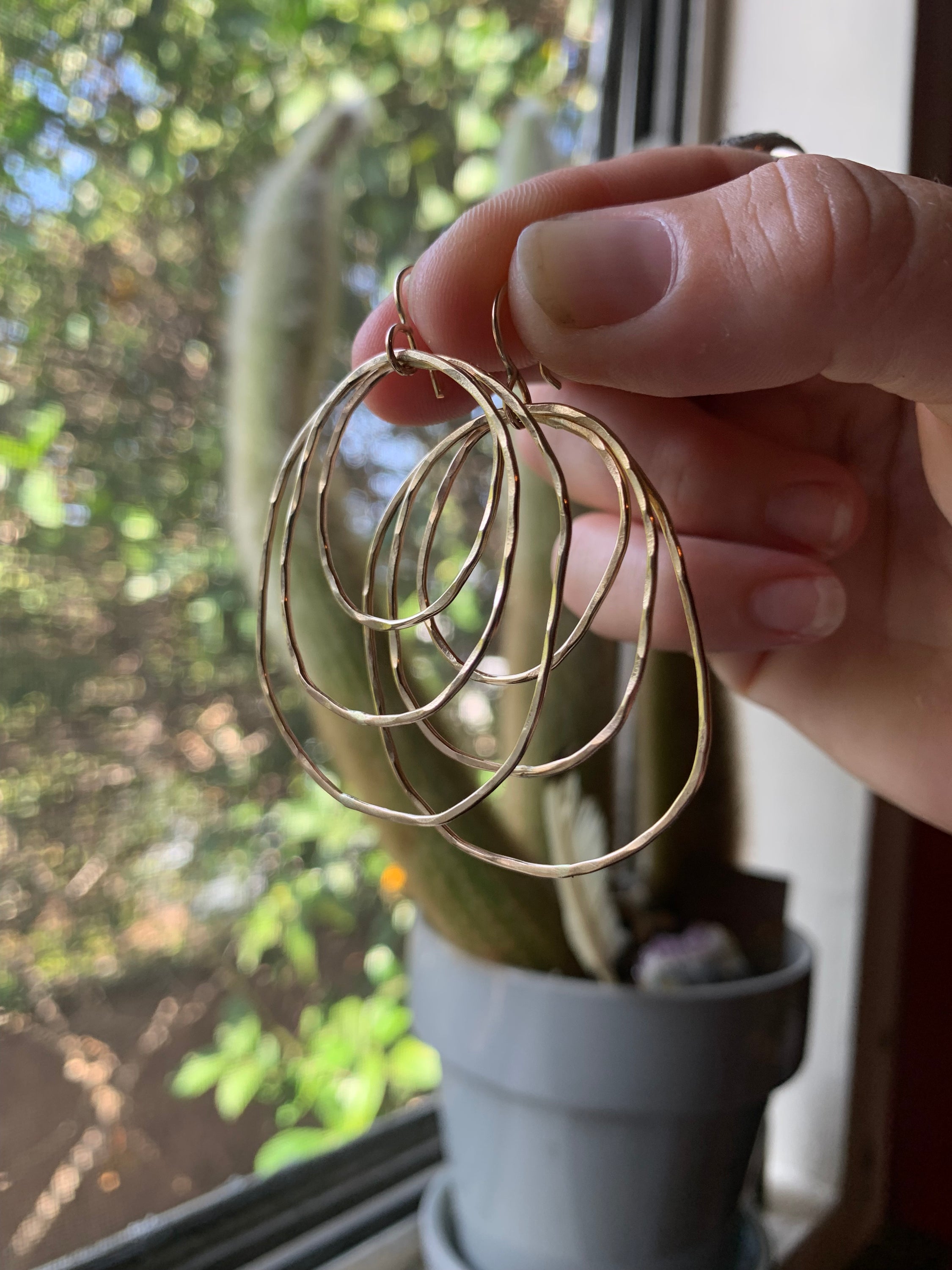 Handmade Peacock Feather Earrings featuring intricate designs inspired by nature, crafted from recycled metals in Hermosa Beach, California.