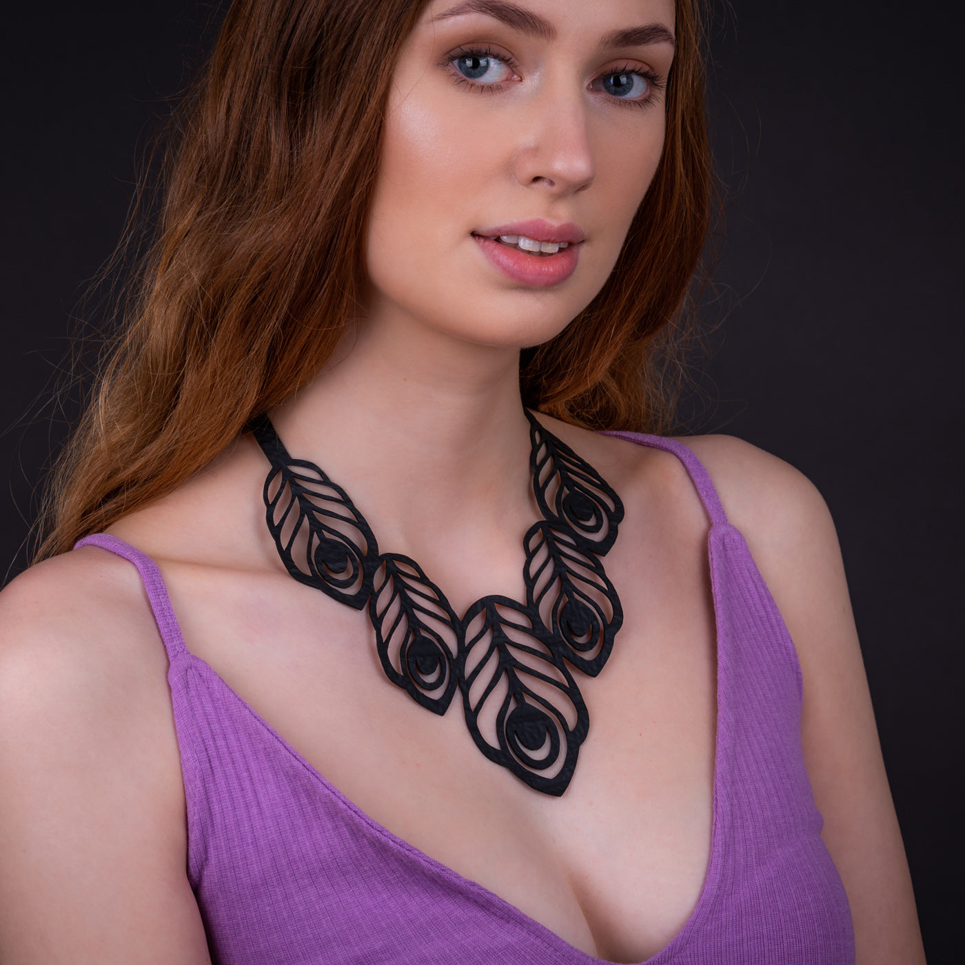 Handcrafted Peacock Feather Necklace made from recycled rubber, featuring a unique peacock feather design on a black inner tube cord.