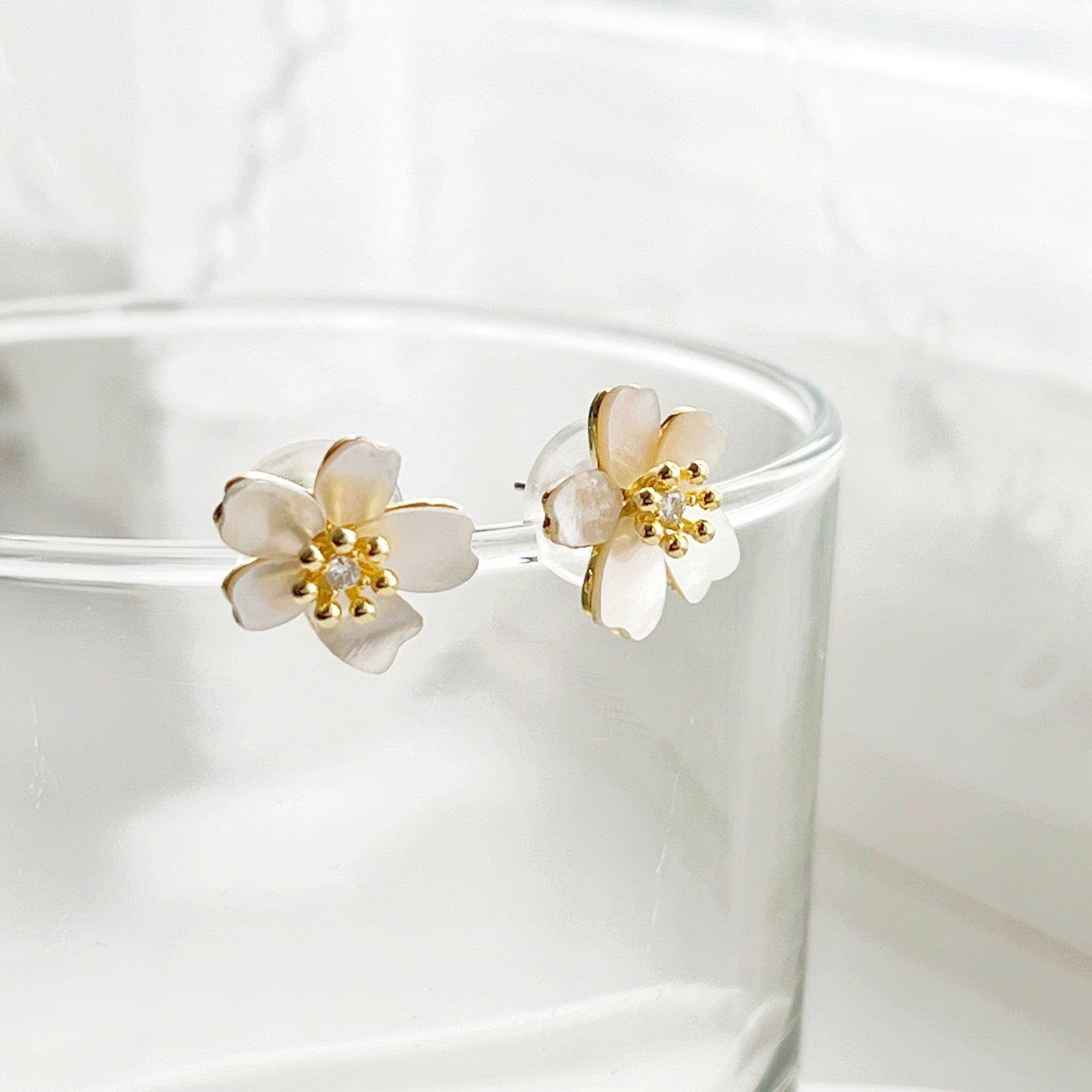 A pair of elegant pear flower earrings featuring a shell effect, crafted from sterling silver and gold plated bronze.