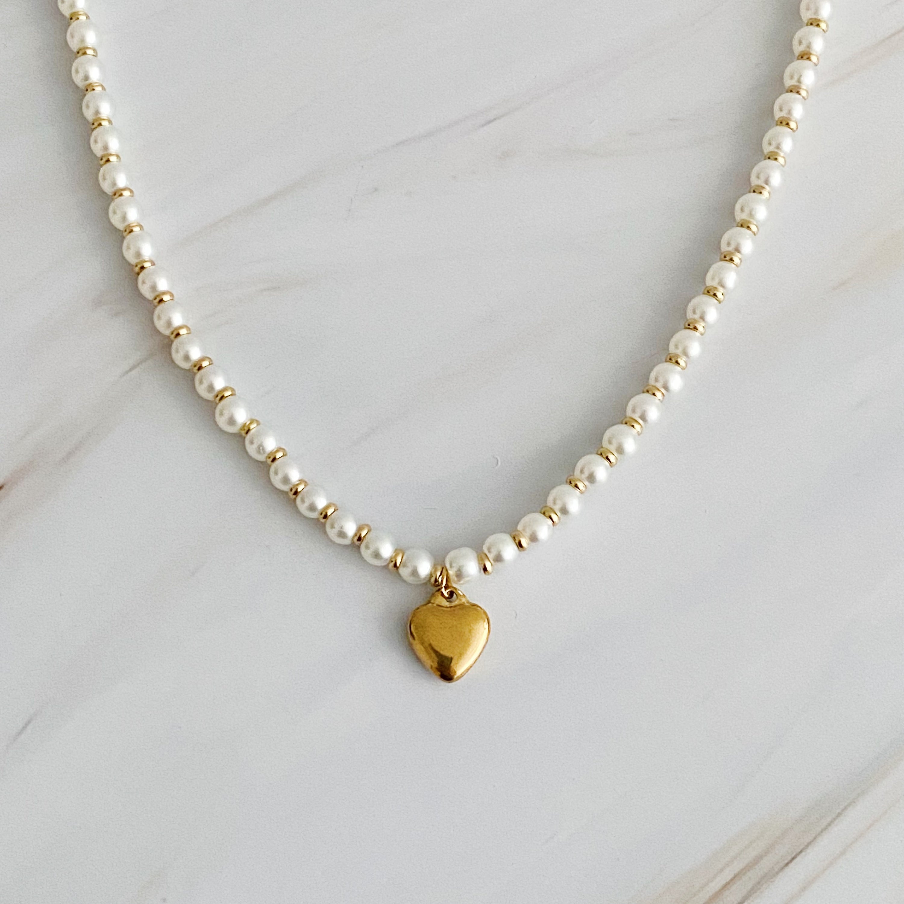 A stylish Pearl and Gold Bauble Heart Necklace featuring alternating pearl and gold beads with a golden heart charm.