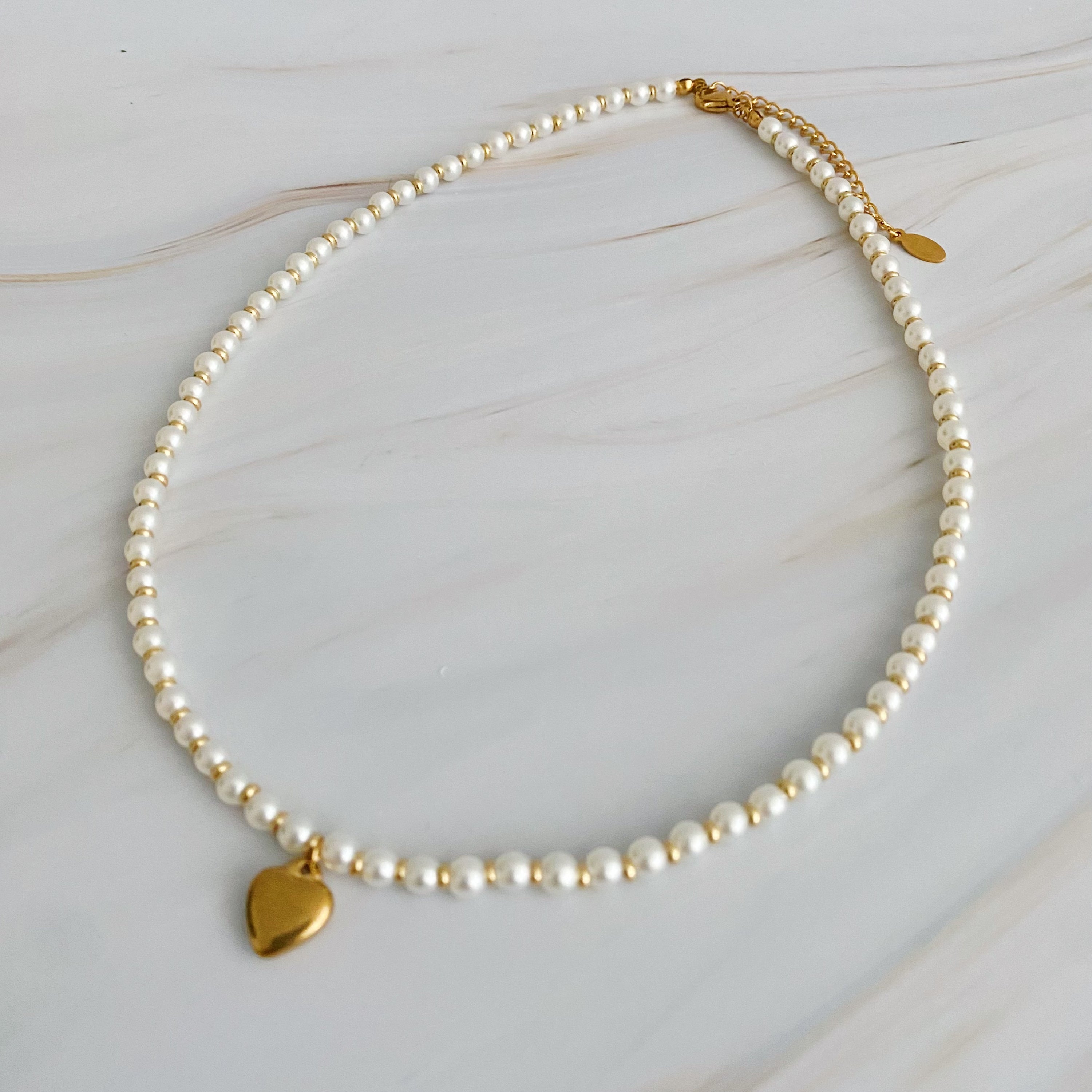 A stylish Pearl and Gold Bauble Heart Necklace featuring alternating pearl and gold beads with a golden heart charm.