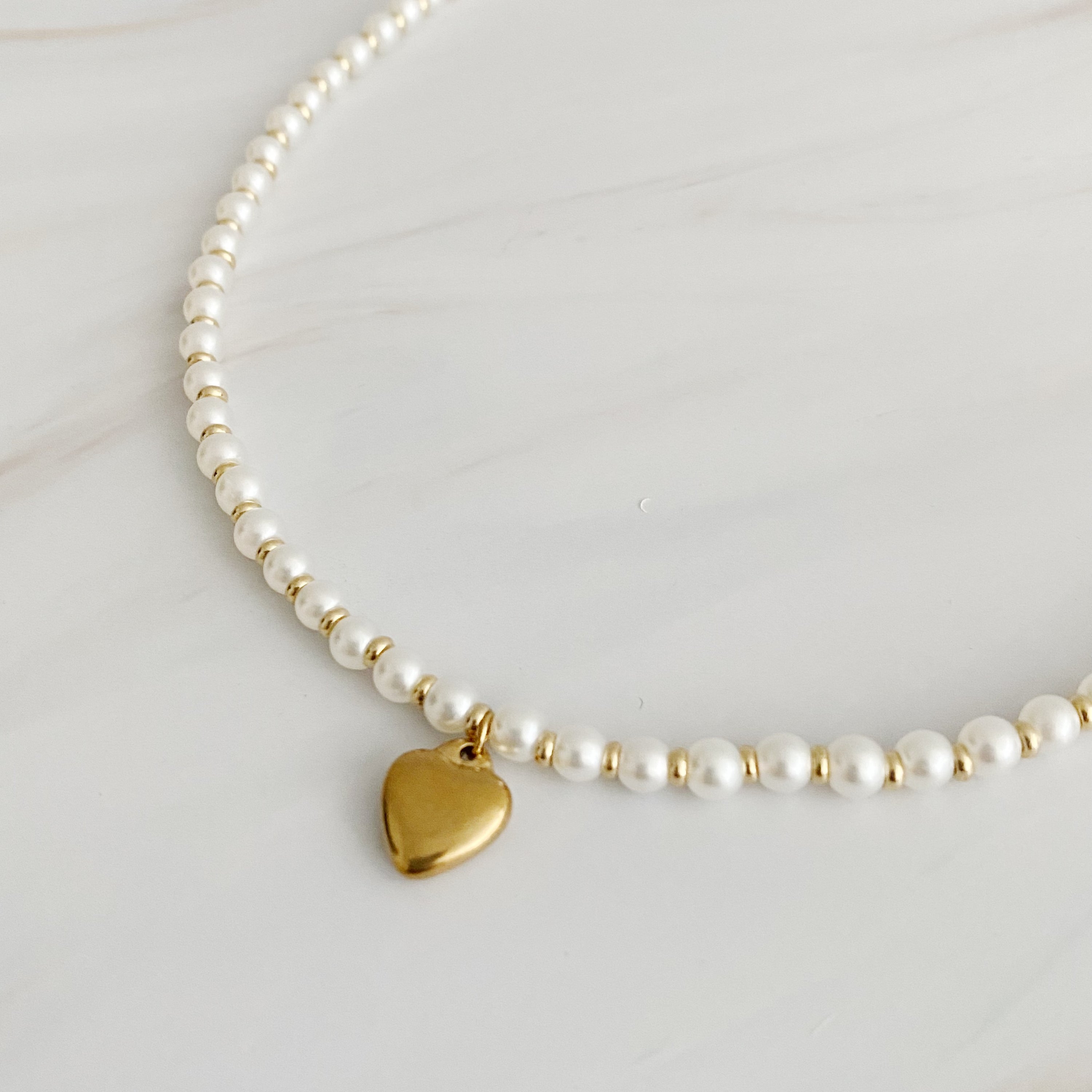 A stylish Pearl and Gold Bauble Heart Necklace featuring alternating pearl and gold beads with a golden heart charm.