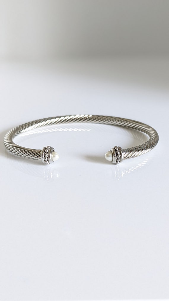 Elegant Pearl Bangle Bracelet with twisted cable design in gold and silver options, featuring a synthetic pearl accent.