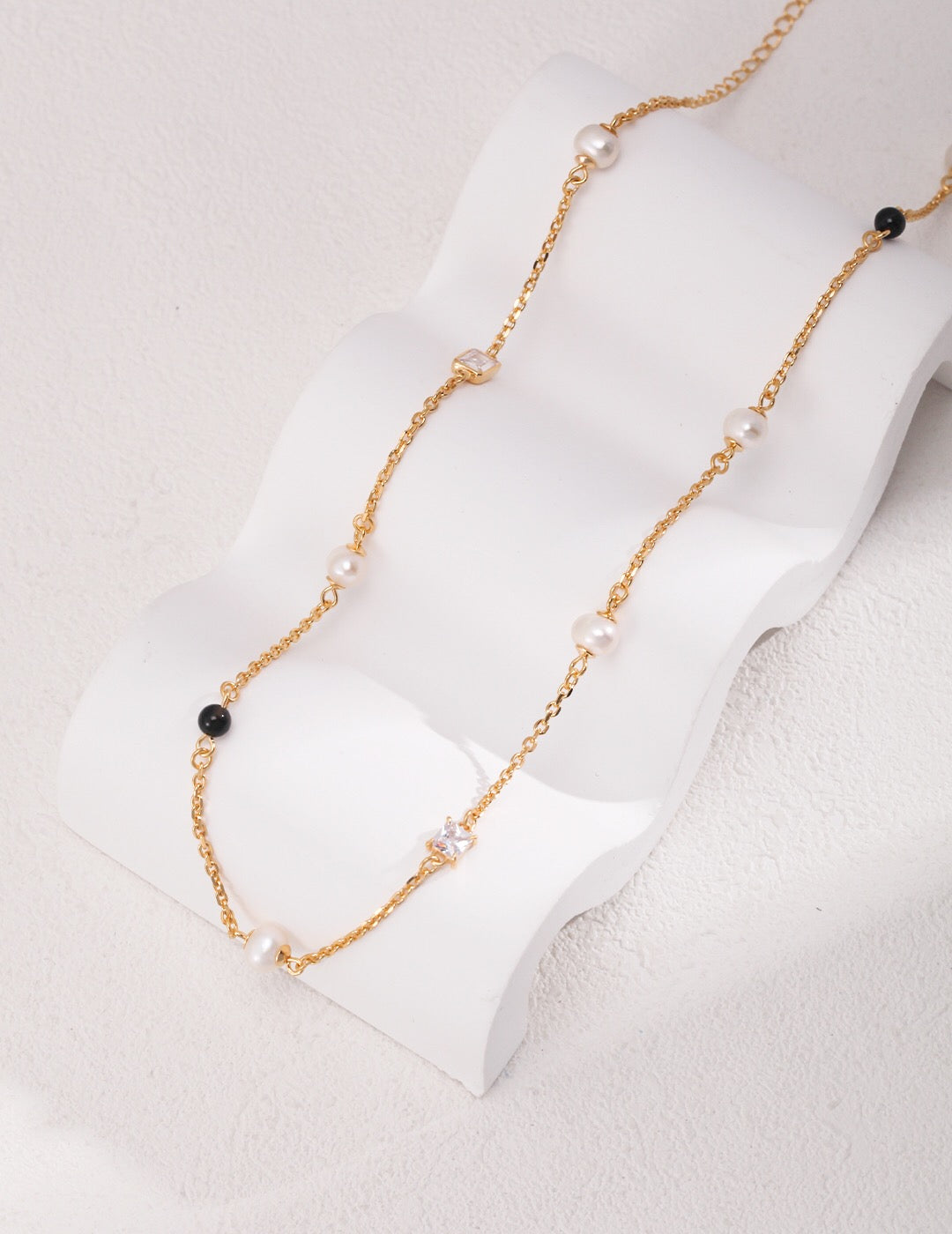 Elegant Pearl Black Onyx Cubic Zirconia Chain Necklace featuring black agate, freshwater pearls, and gold vermeil, showcasing its luxurious design.