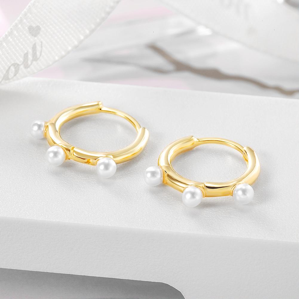 Elegant Pearl Charm Huggie Earrings made of stainless steel with gold plating, featuring a stylish pearl charm.