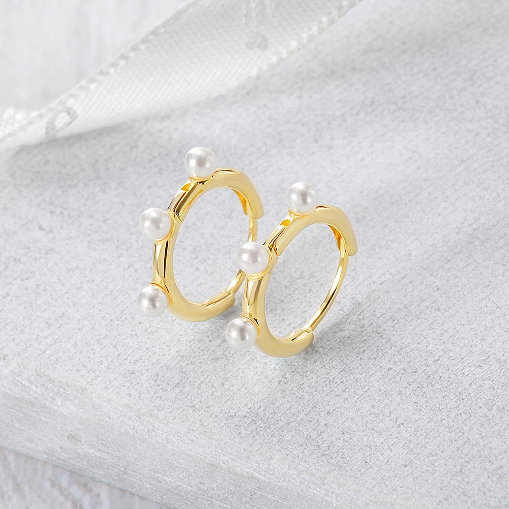 Elegant Pearl Charm Huggie Earrings made of stainless steel with gold plating, featuring a stylish pearl charm.