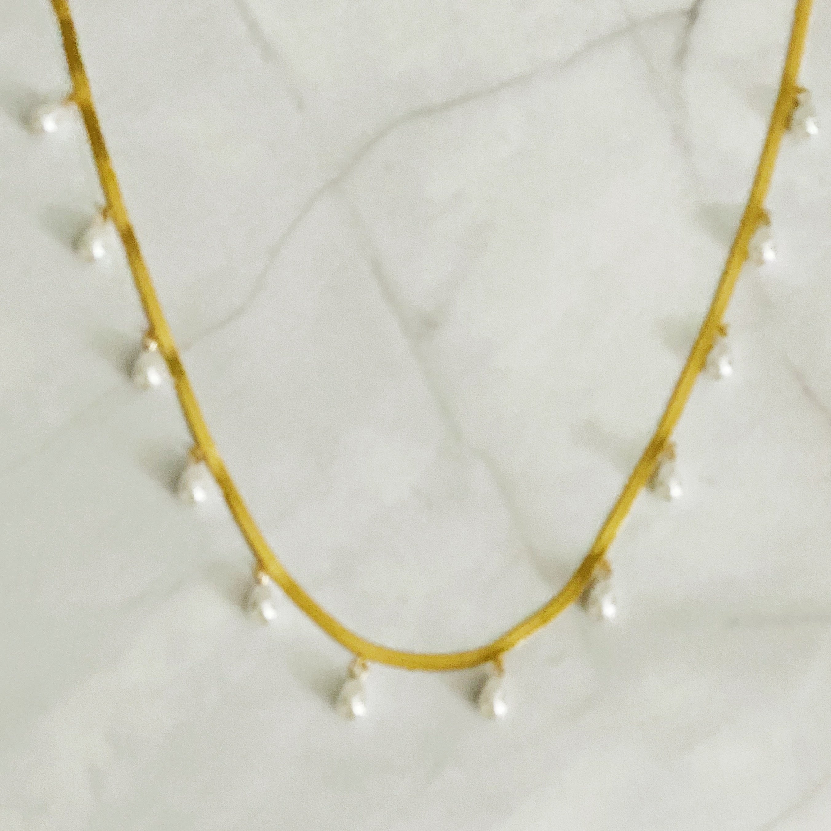 Elegant Pearl Drop Herringbone Chain Necklace featuring teardrop-shaped glass pearls on a gold plated stainless steel chain.