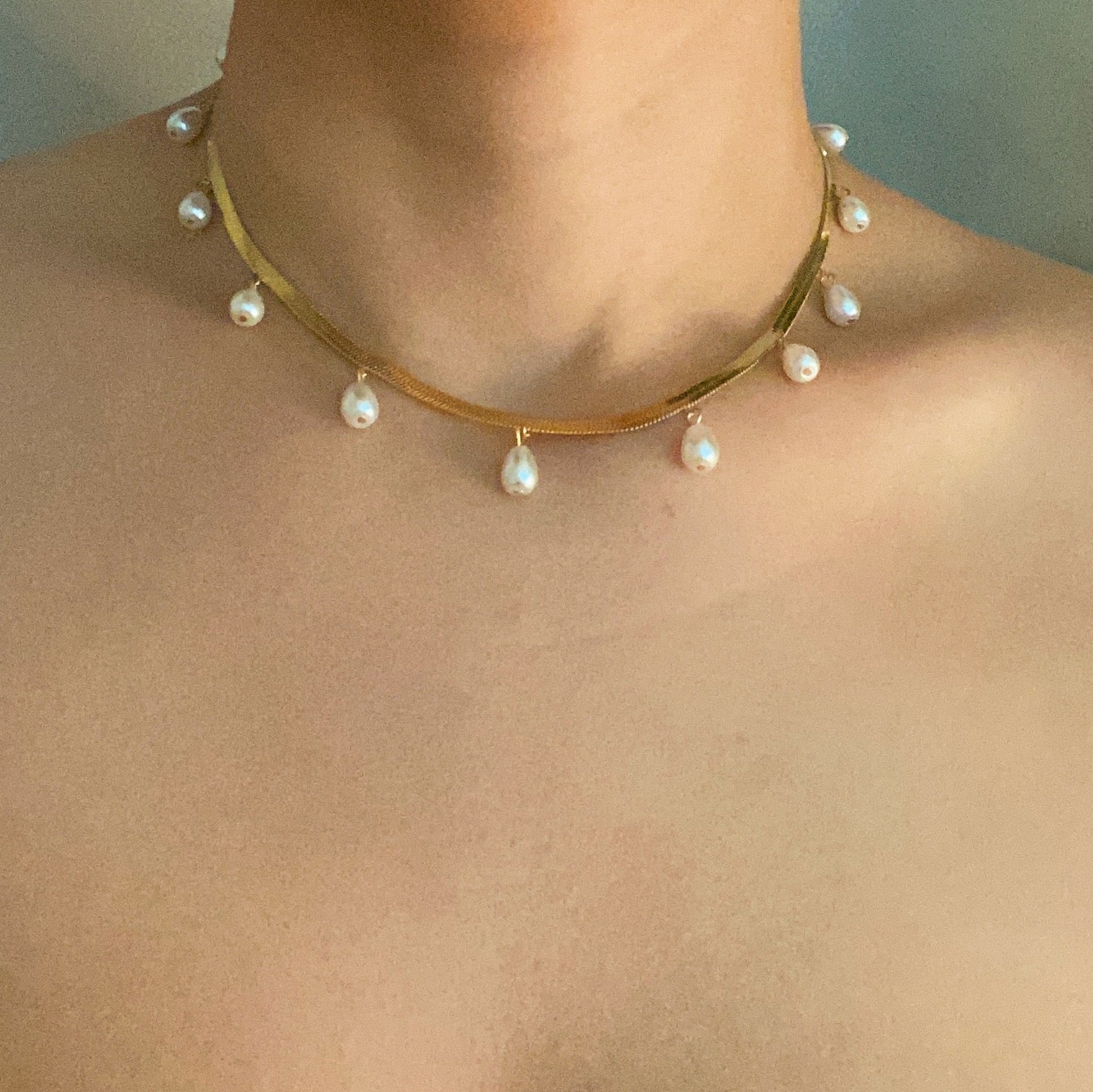 Elegant Pearl Drop Herringbone Chain Necklace featuring teardrop-shaped glass pearls on a gold plated stainless steel chain.