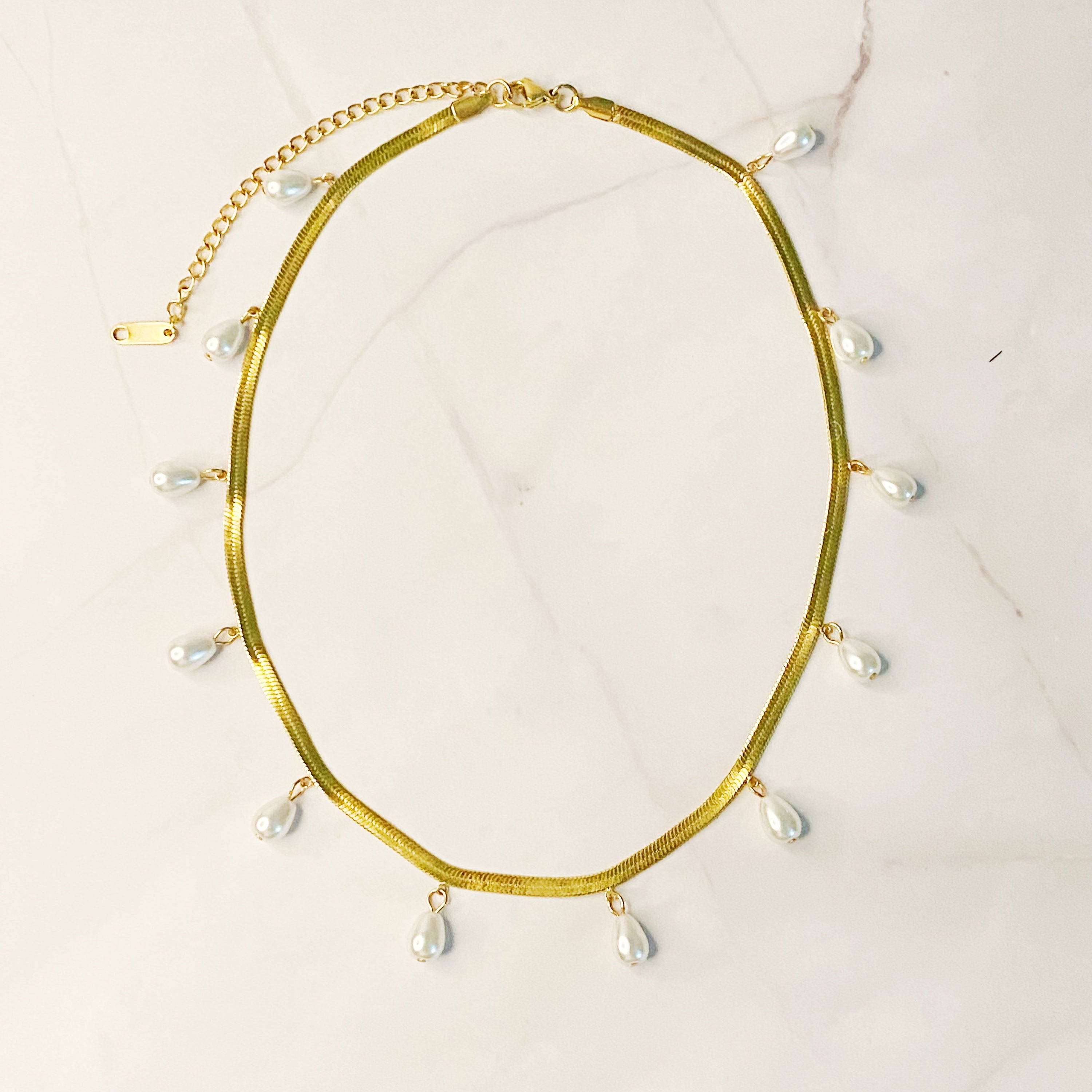 Elegant Pearl Drop Herringbone Chain Necklace featuring teardrop-shaped glass pearls on a gold plated stainless steel chain.