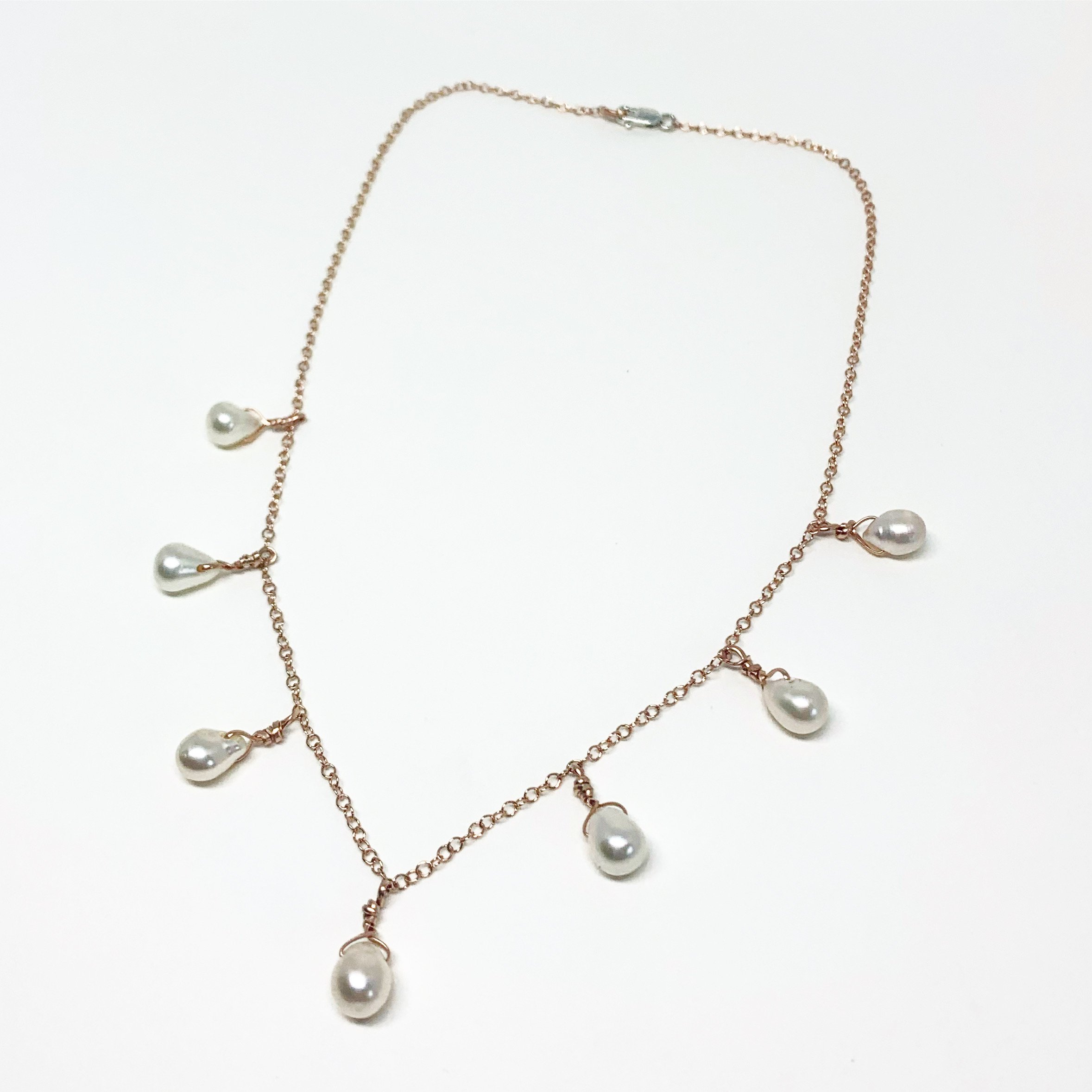 Elegant Pearl Teardrop Necklace featuring seven white freshwater pearls on a sparkling cable chain, available in sterling silver, gold, or rose gold.