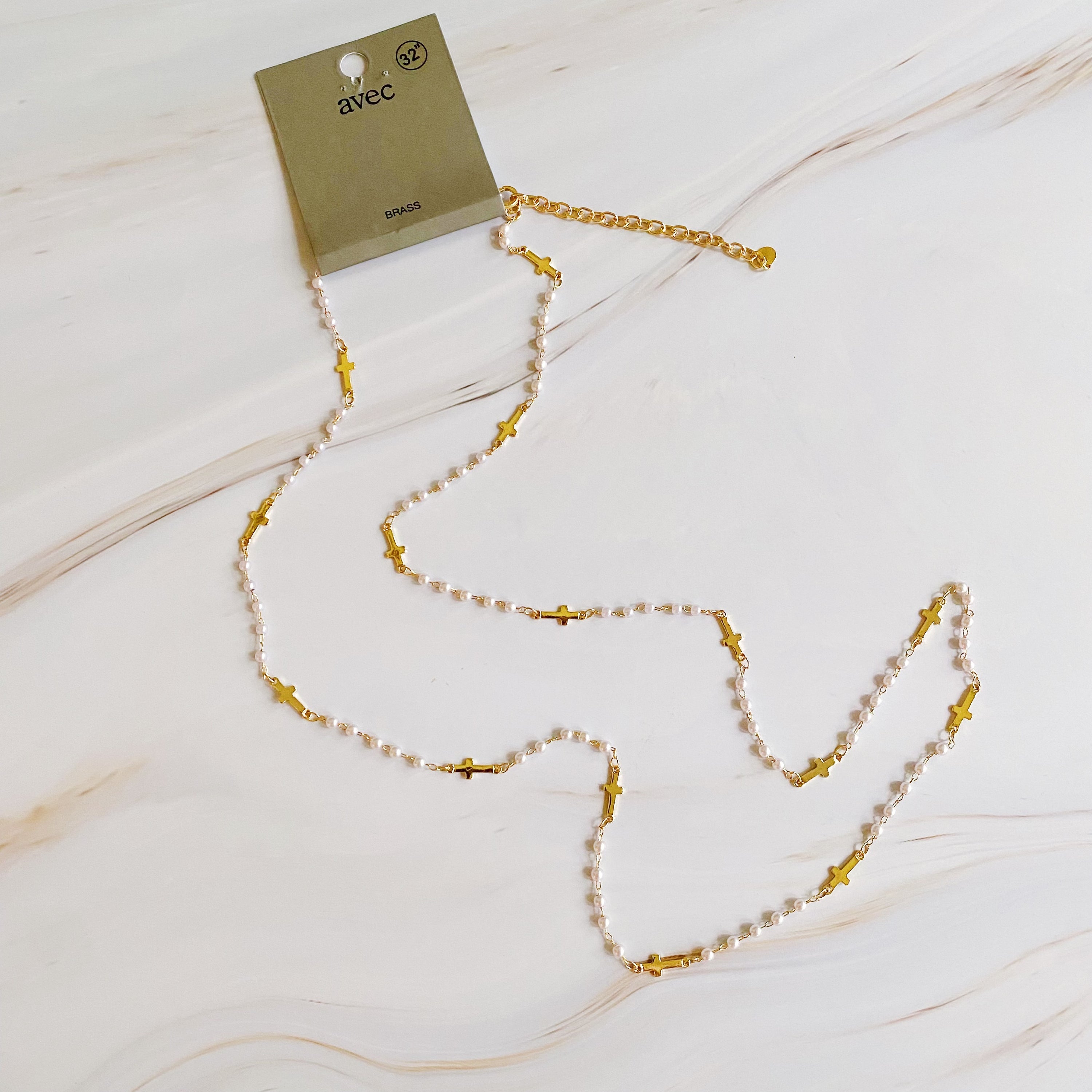 A stylish Pearls And Crosses Long Necklace featuring golden crosses and pearl beads, showcasing its elegant design and versatility.