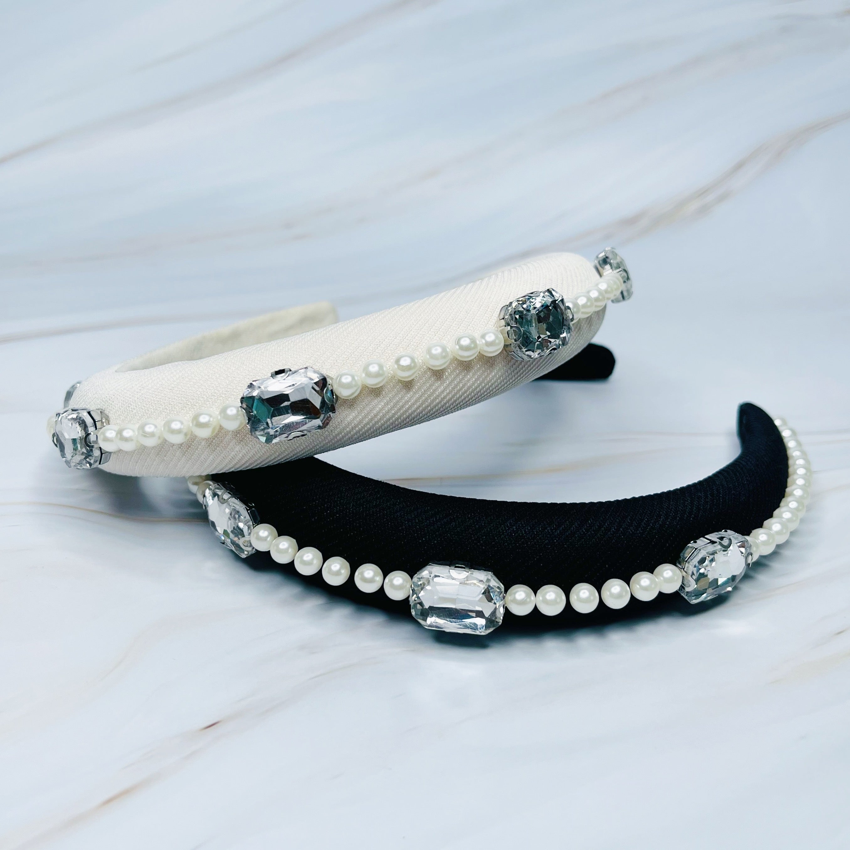 A luxurious Pearls And Jewels Lined Headband featuring elegant pearl and jewel embellishments on a soft material.