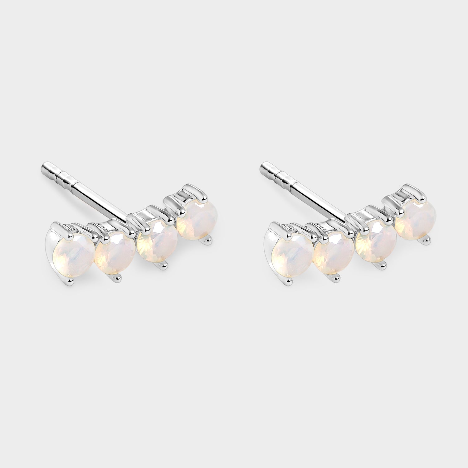 Pendientes de ópalos blancos en línea curva, fabricados en plata de alta calidad o bañados en oro de 18K, mostrando su elegante diseño.