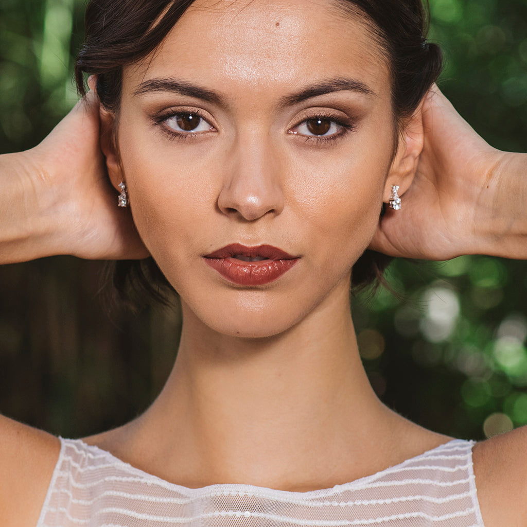 Pendientes de plata con circonitas blancas brillantes, colgando de un gancho elegante.