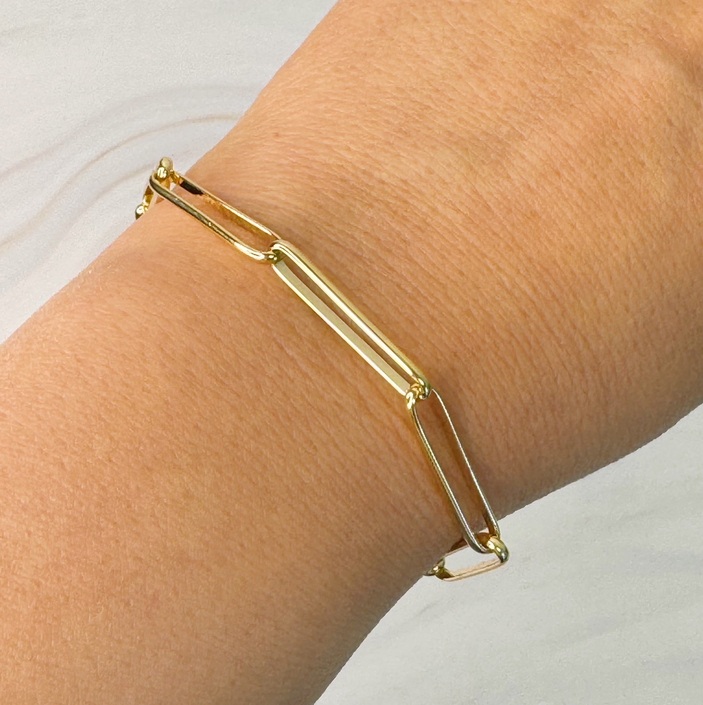 A sleek Perfect Clip Link Chain Bracelet made of 18k gold plated brass, featuring linked clips and a 2-inch extender for adjustable fit.