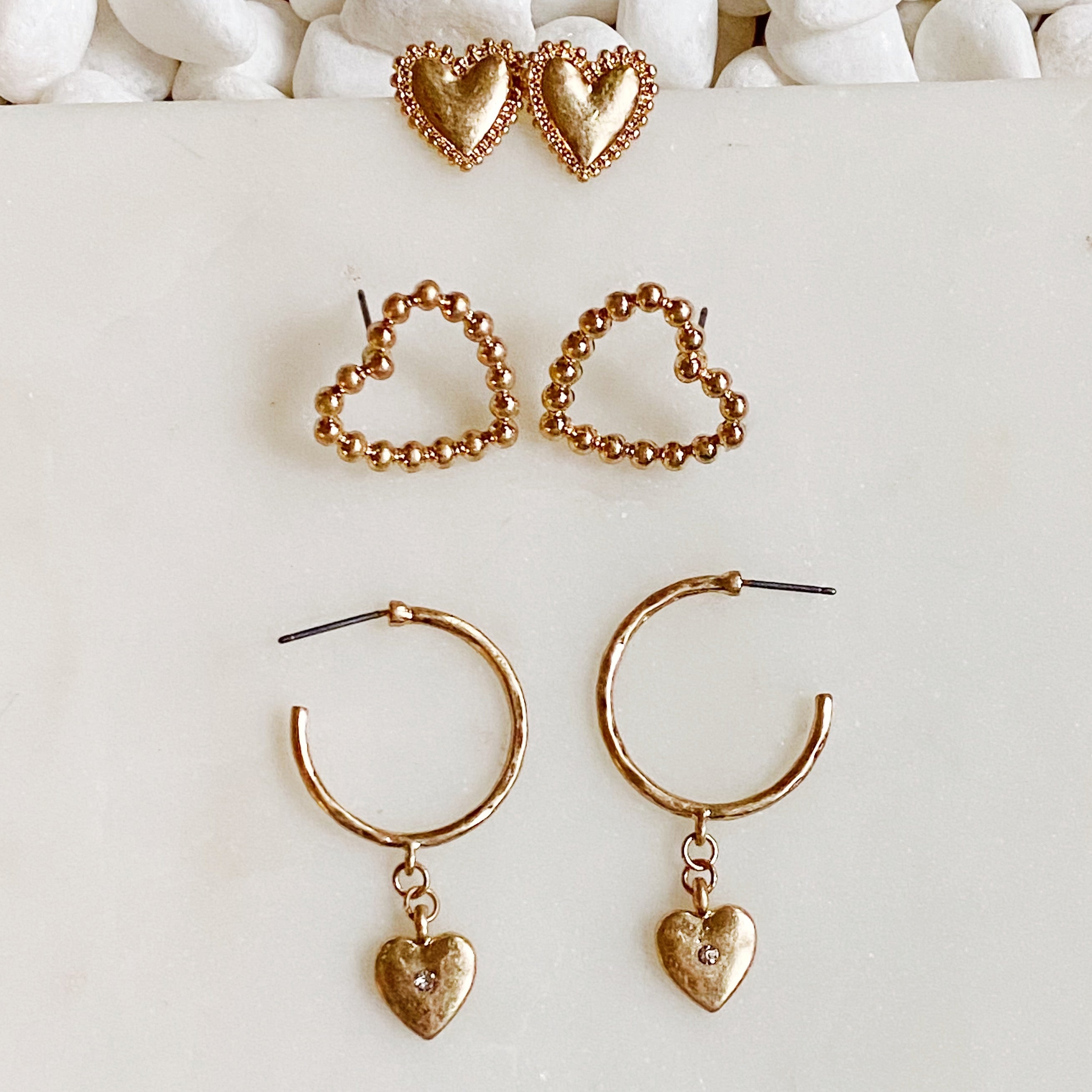 A stylish set of 3 heart earrings in different designs, showcasing versatility and elegance.