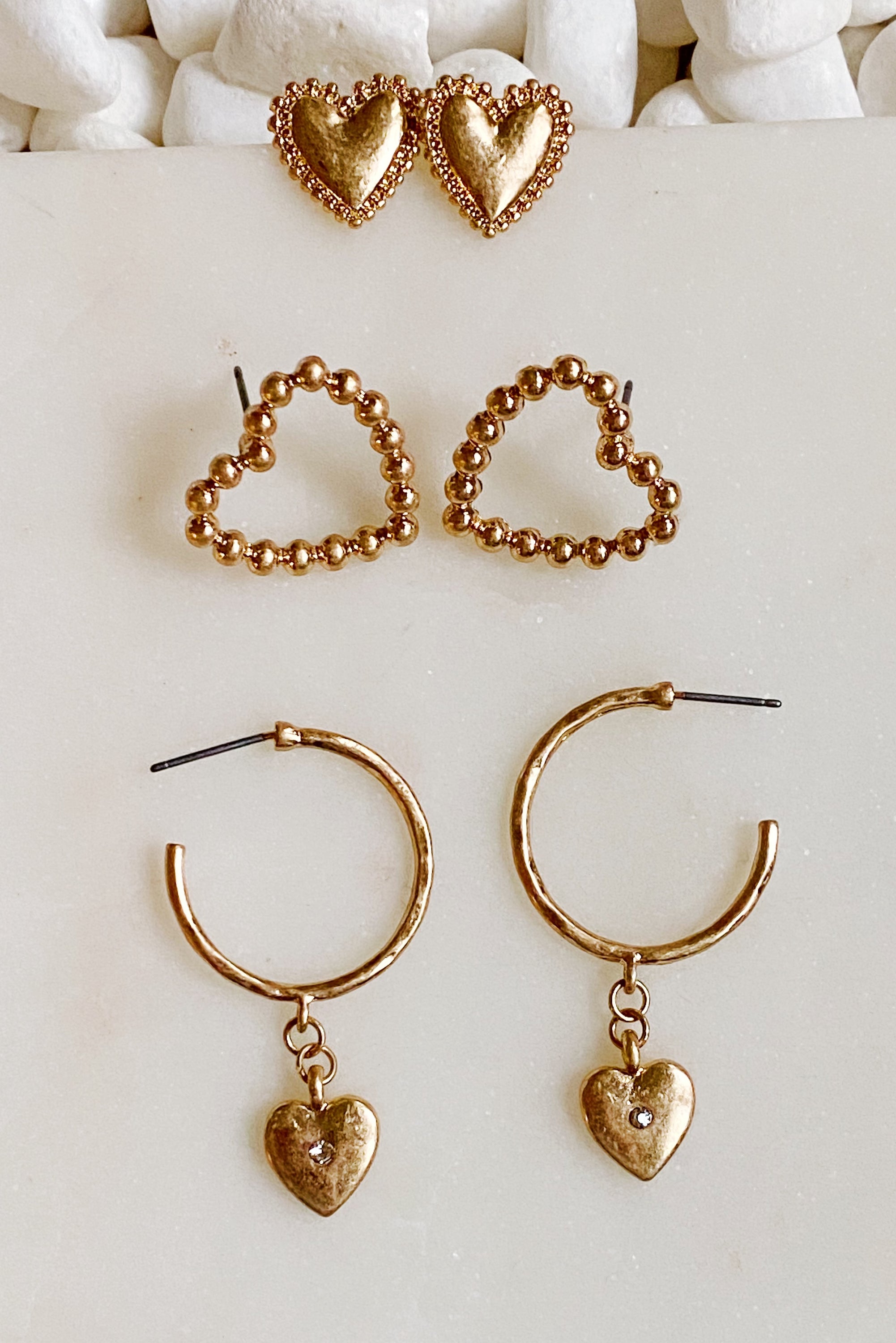 A stylish set of 3 heart earrings in different designs, showcasing versatility and elegance.