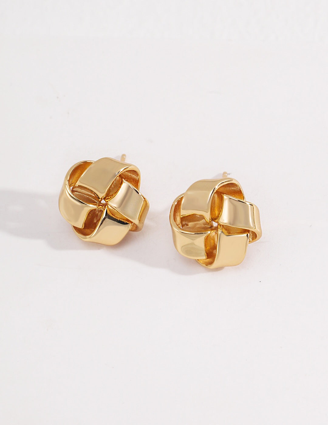 A pair of Petite Love Knot Stud Earrings made of gold vermeil, showcasing a delicate knot design, perfect for everyday wear.