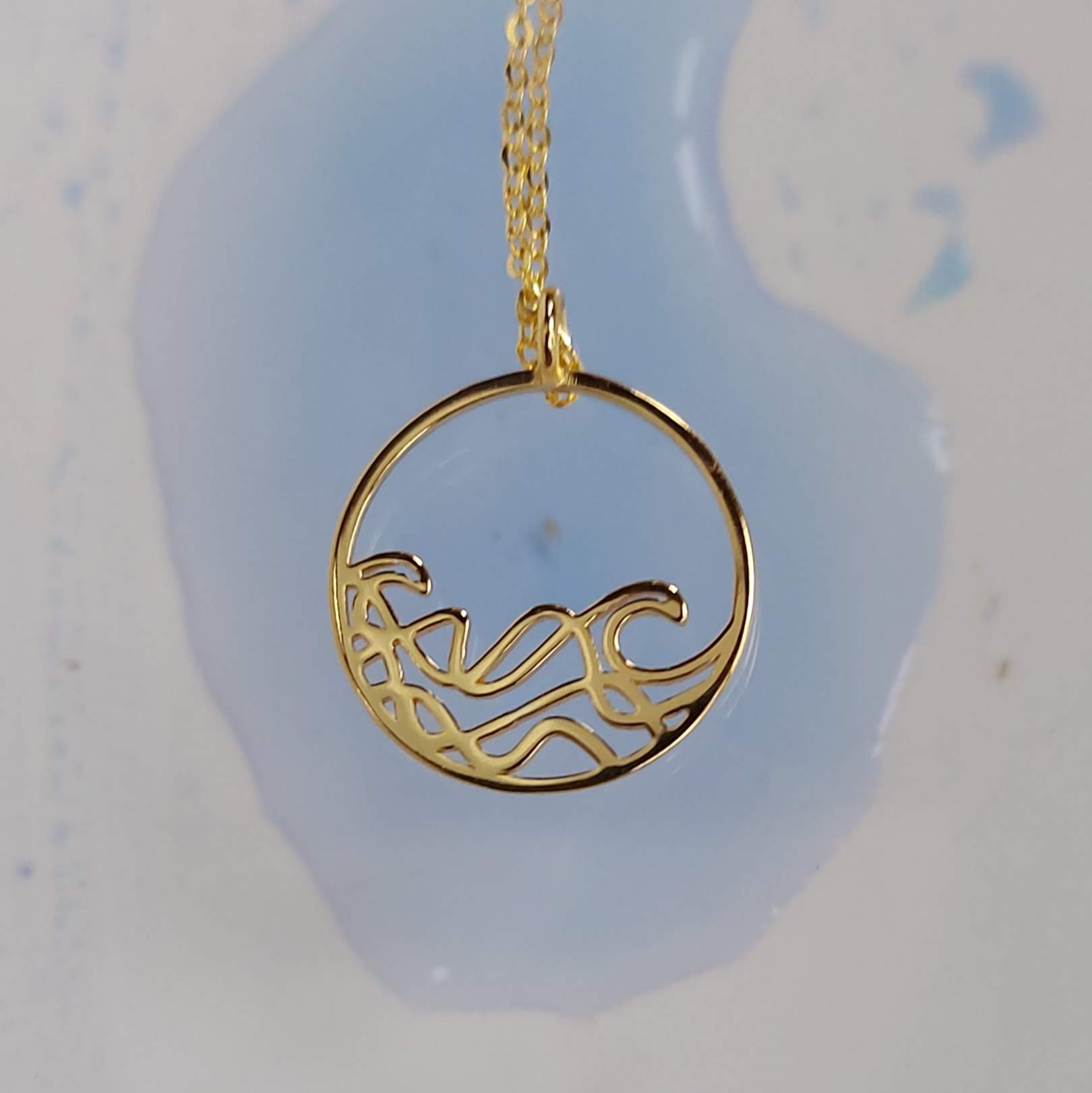 A delicate 20mm Petite Sombrio Surf Wave Circle Necklace in 925 sterling silver with rhodium, rose gold, and yellow gold plating options.