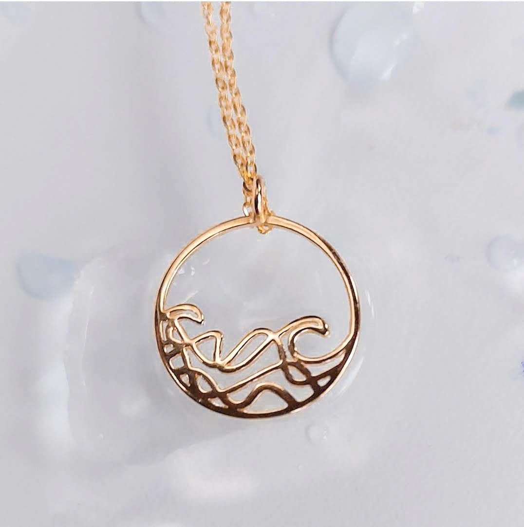 A delicate 20mm Petite Sombrio Surf Wave Circle Necklace in 925 sterling silver with rhodium, rose gold, and yellow gold plating options.