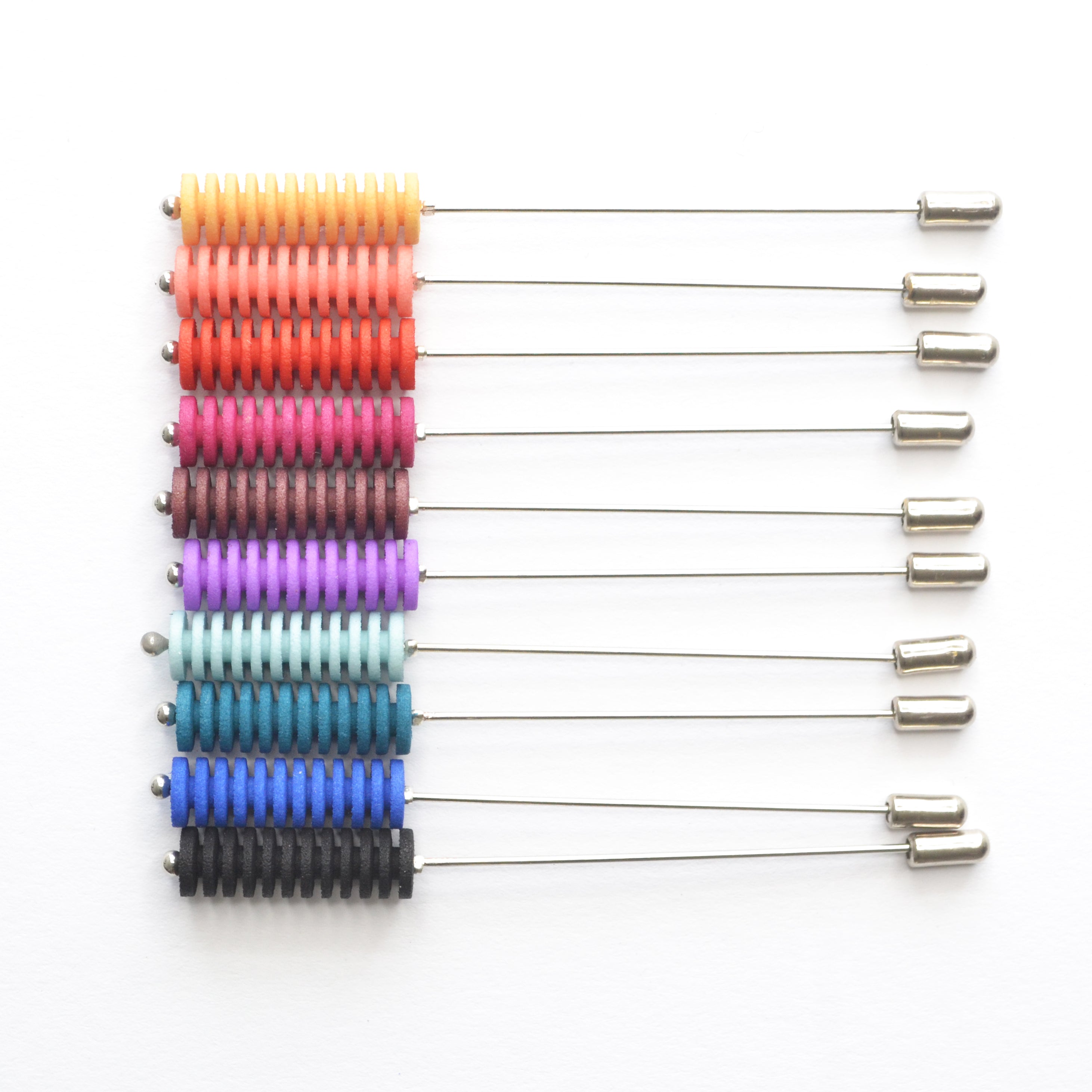 Optical Pin Brooch in various bold colors, showcasing its minimalistic design and versatility as a fashion accessory.