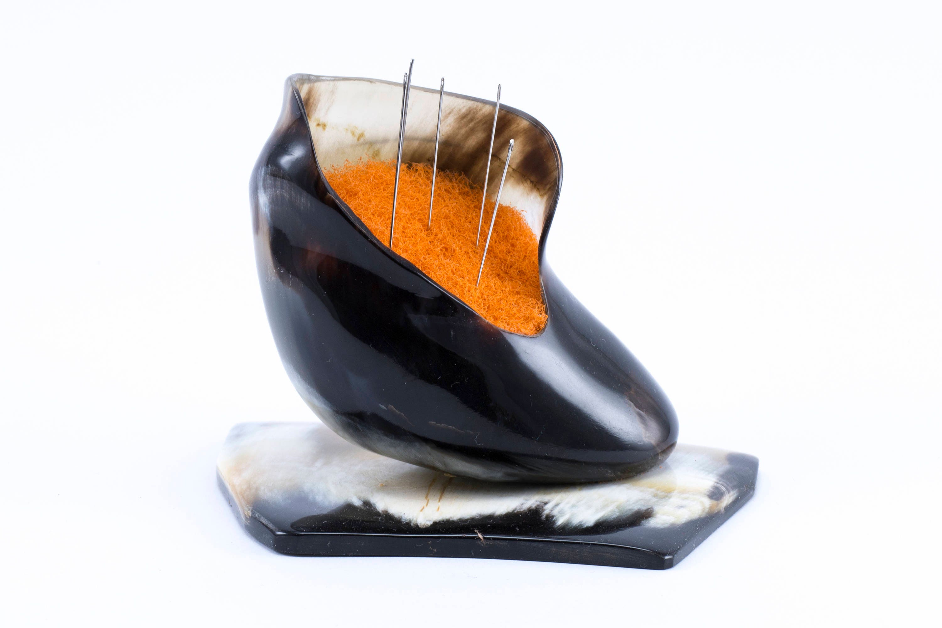 Handmade pincushion shaped like a little boot, crafted from natural bull's horn with a polished surface.