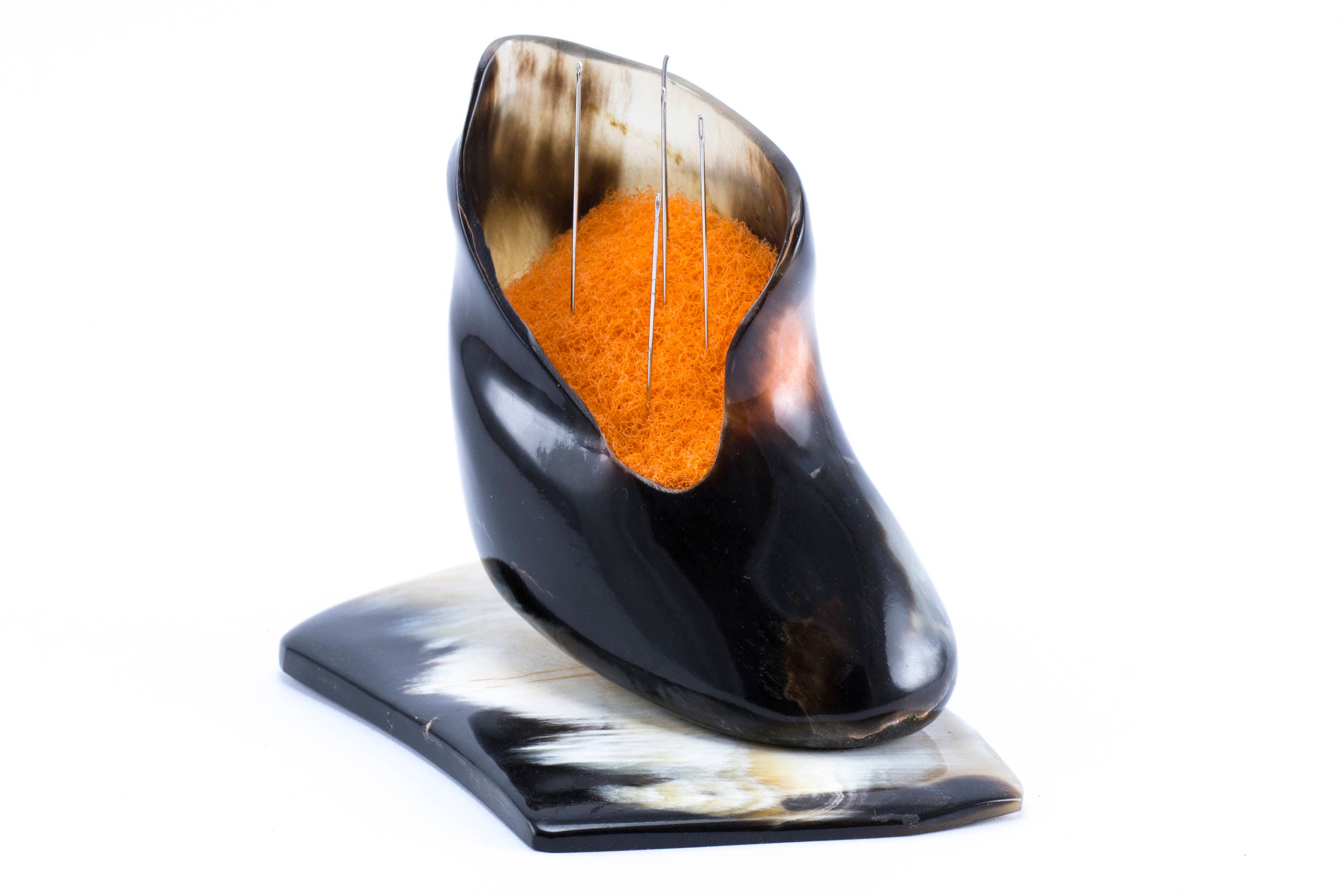 Handmade pincushion shaped like a little boot, crafted from natural bull's horn with a polished surface.