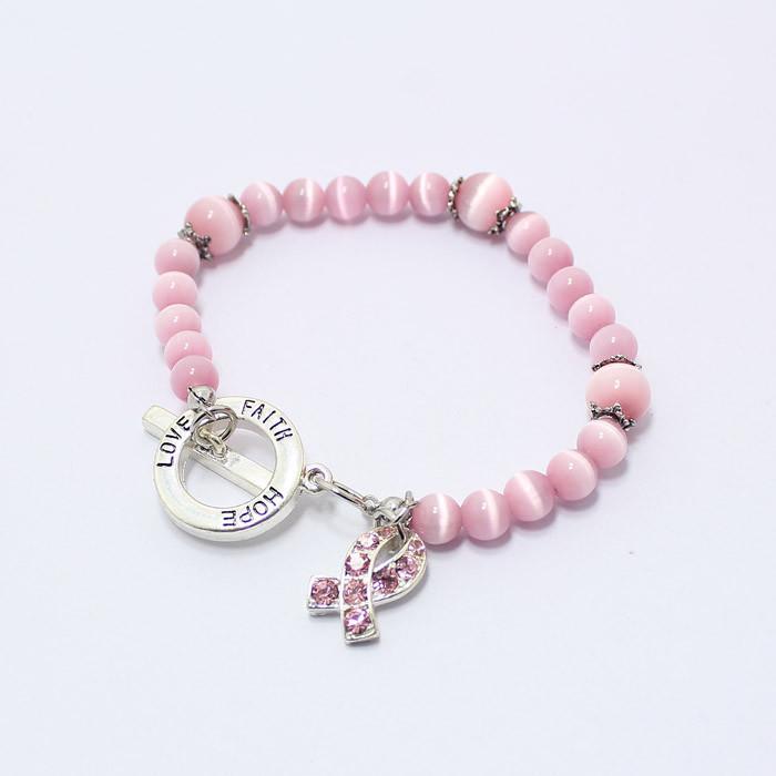 Pink Cat Eye Cancer Bracelet featuring glass beads and a silver plated design, symbolizing breast cancer awareness with a ribbon.