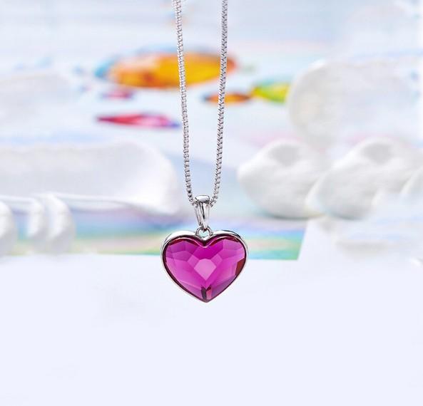 A beautiful heart-shaped necklace featuring pink elements stone, crafted in 14K white gold plating with a link chain.