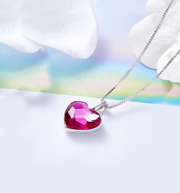 A beautiful heart-shaped necklace featuring pink elements stone, crafted in 14K white gold plating with a link chain.