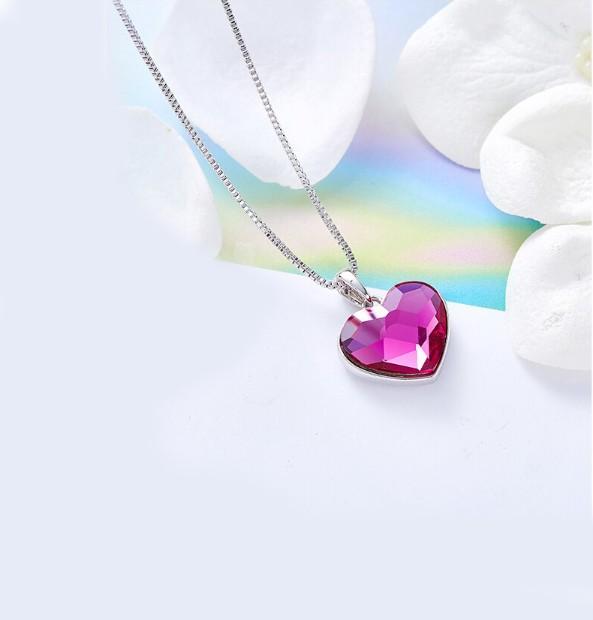 A beautiful heart-shaped necklace featuring pink elements stone, crafted in 14K white gold plating with a link chain.