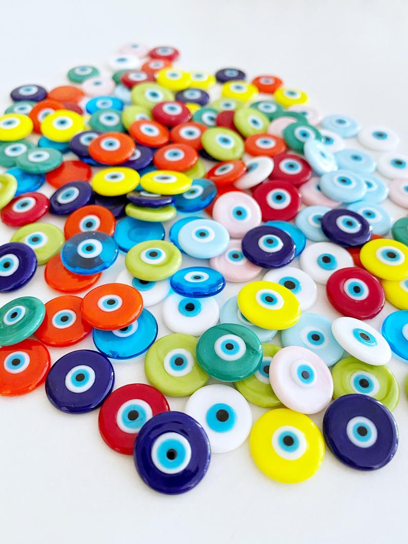 A collection of pink Murano glass evil eye cabochons, each 15mm in diameter, showcasing intricate designs and vibrant colors.