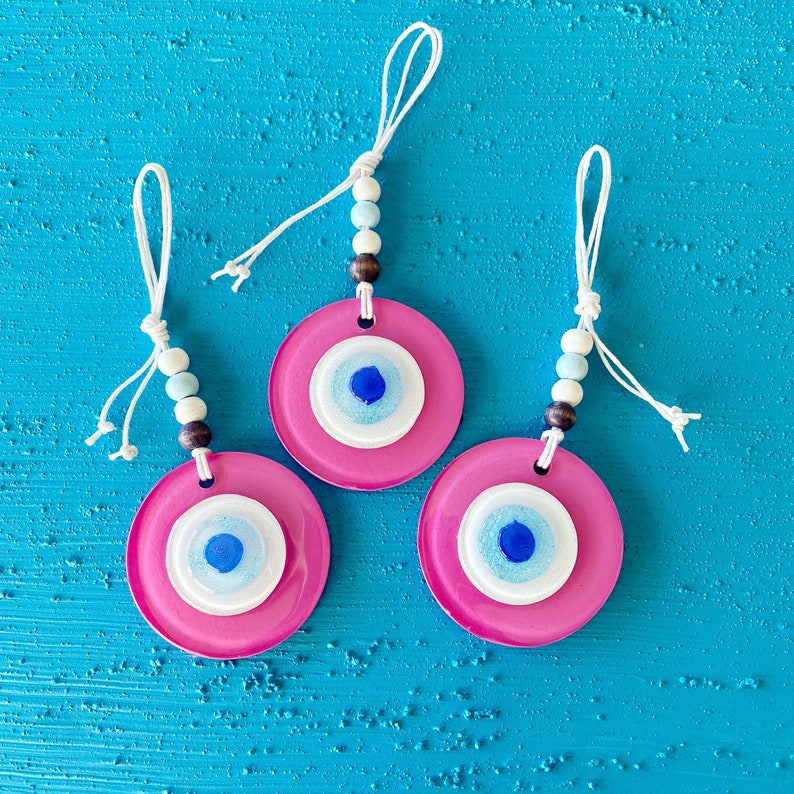 A beautiful handmade Pink Evil Eye Glass Bead wall hanging, featuring a vibrant pink color and intricate design, symbolizing protection and purity.