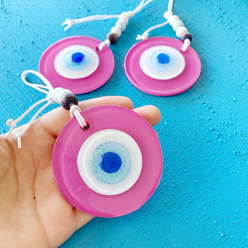 A beautiful handmade Pink Evil Eye Glass Bead wall hanging, featuring a vibrant pink color and intricate design, symbolizing protection and purity.