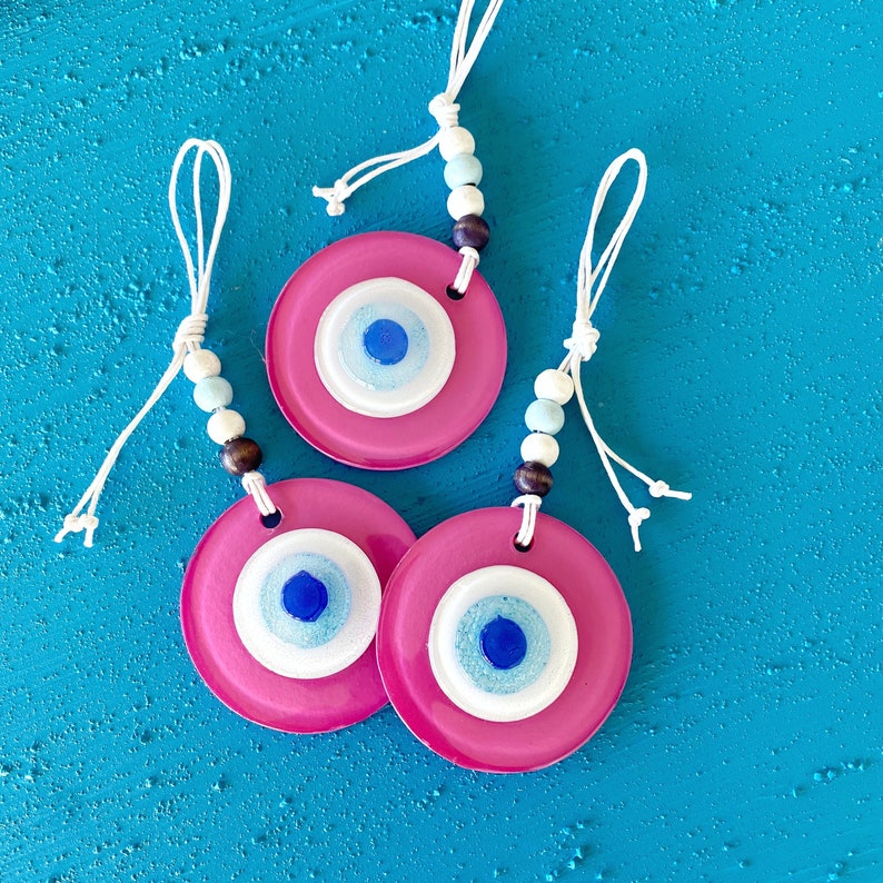 A beautiful handmade Pink Evil Eye Glass Bead wall hanging, featuring a vibrant pink color and intricate design, symbolizing protection and purity.