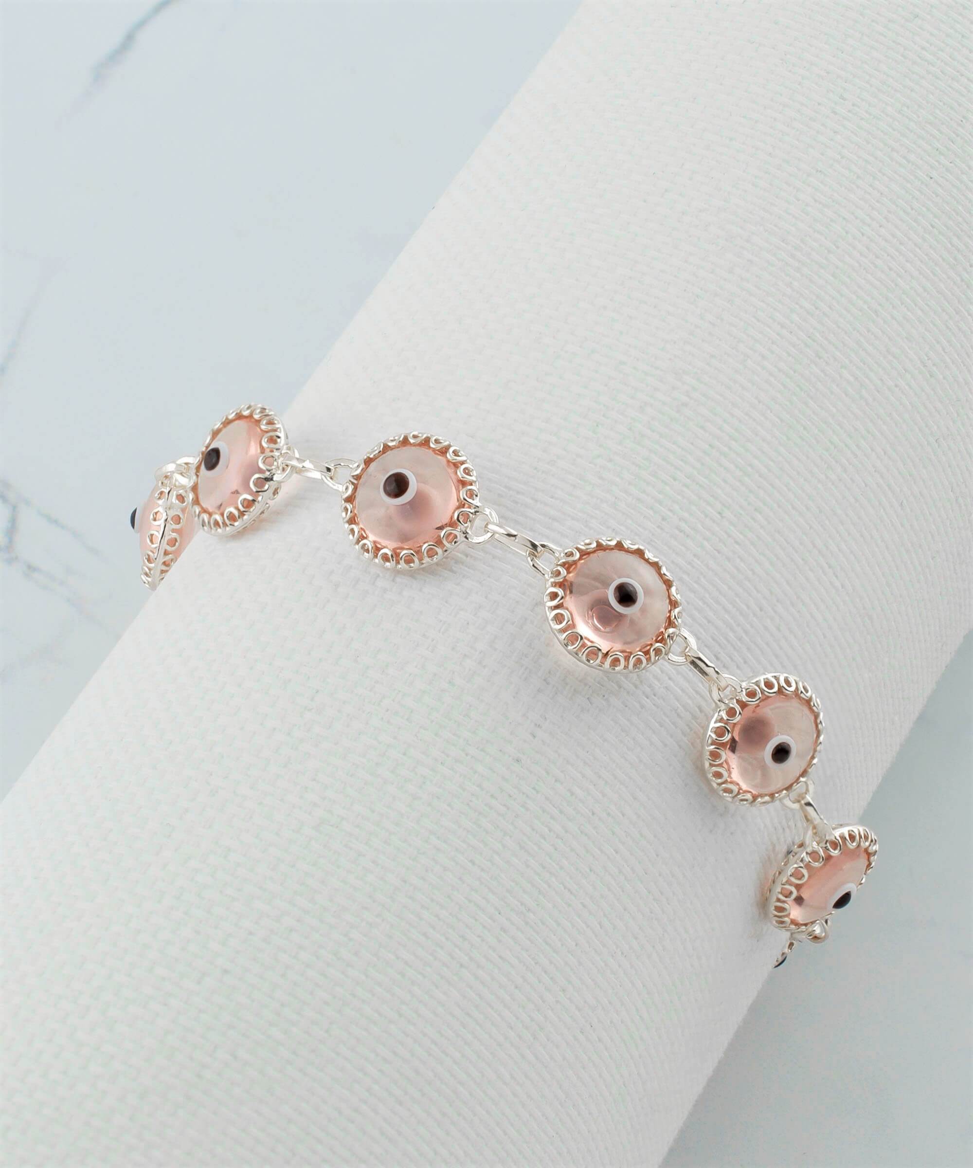 A stylish Pink Evil Eye Sterling Silver Adjustable Link Bracelet featuring a strong rolo chain and protective evil eye beads.