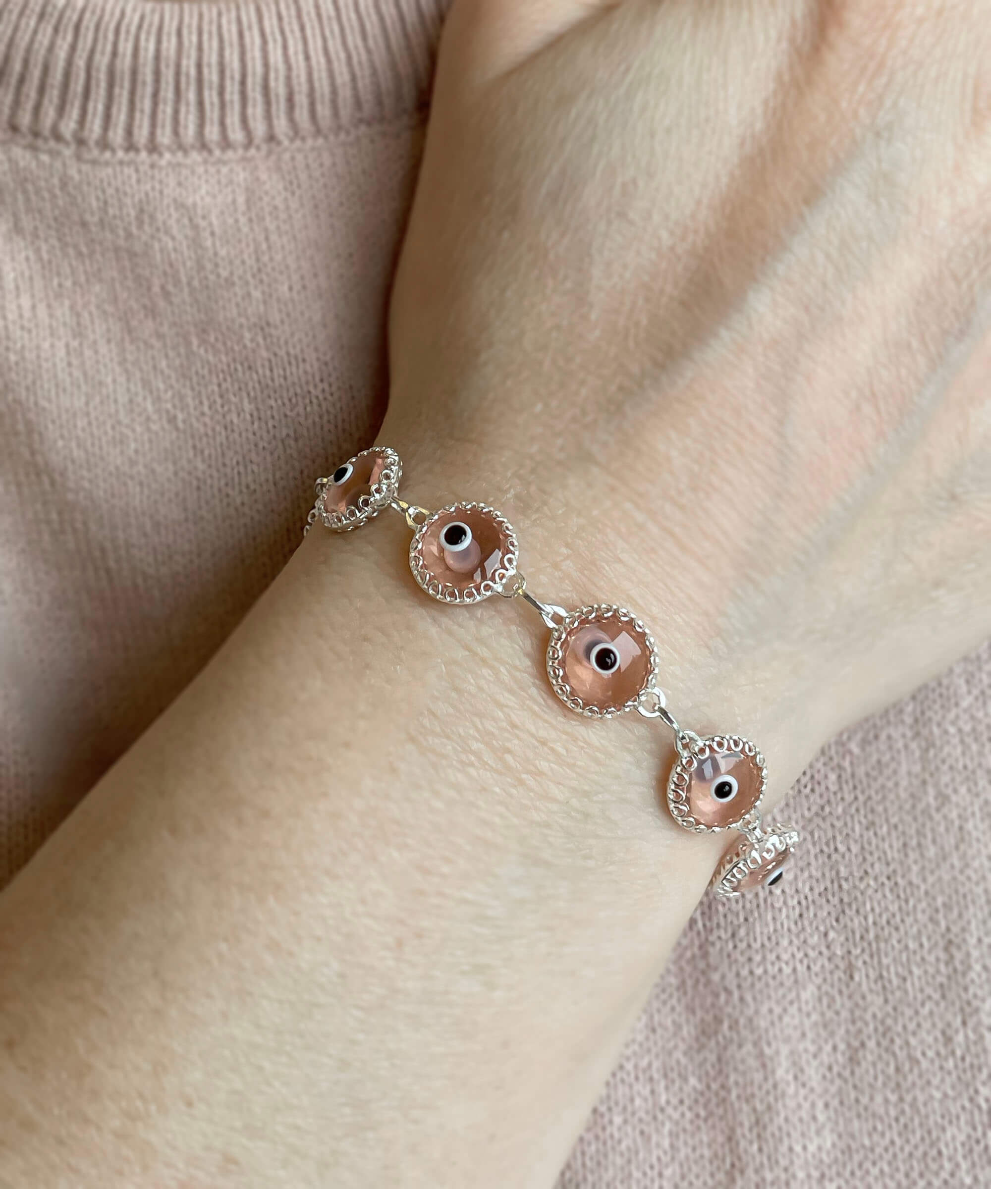 A stylish Pink Evil Eye Sterling Silver Adjustable Link Bracelet featuring a strong rolo chain and protective evil eye beads.