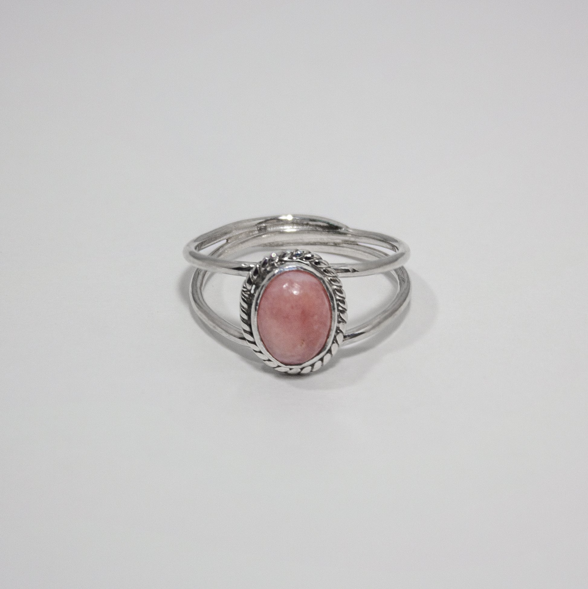 Elegant Pink Opal Oval Double Band Sterling Silver Ring featuring a soft pink gemstone in a twist patterned bezel setting.