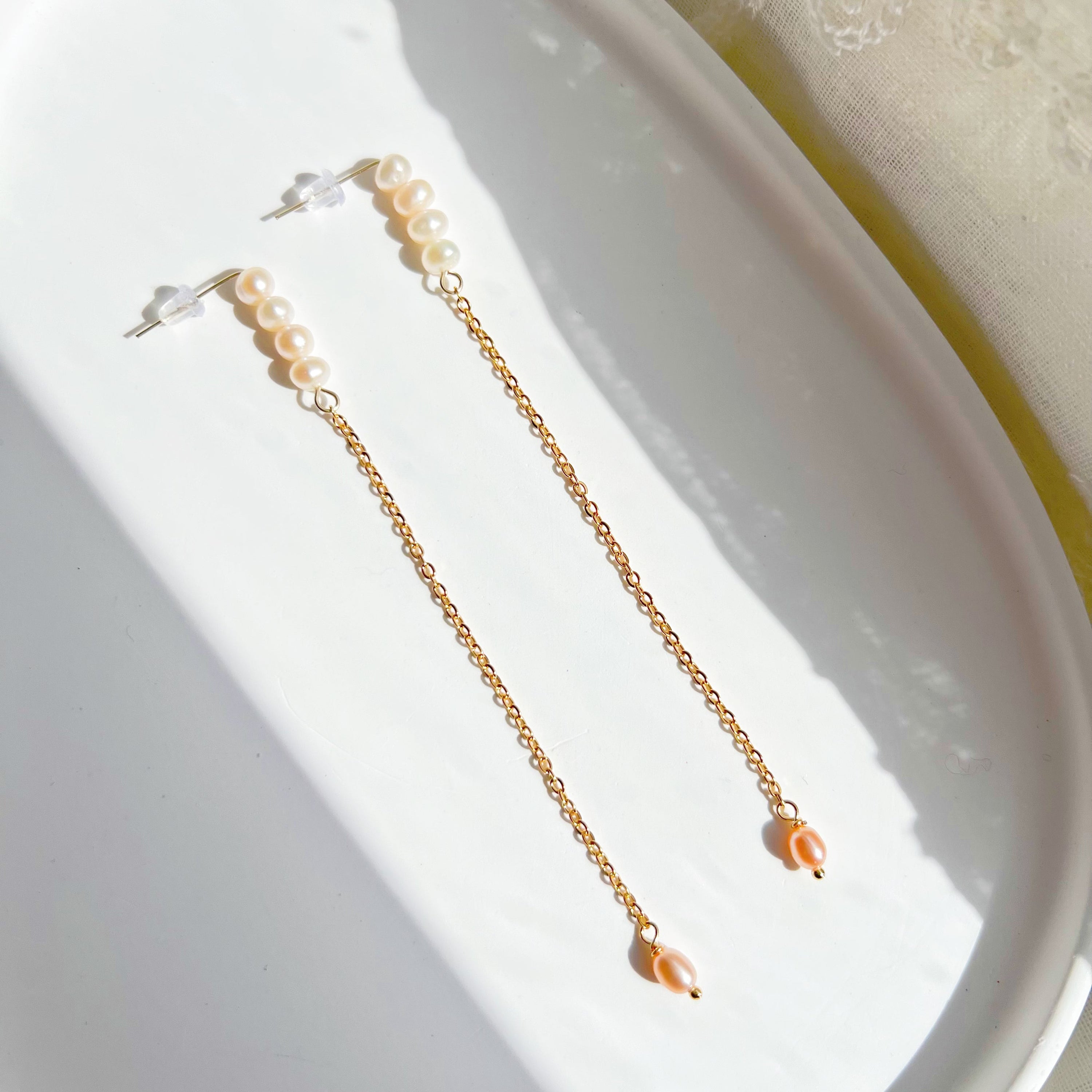 Elegant pink pearl long drop earrings with gold-plated studs, showcasing unique freshwater baroque pearls.