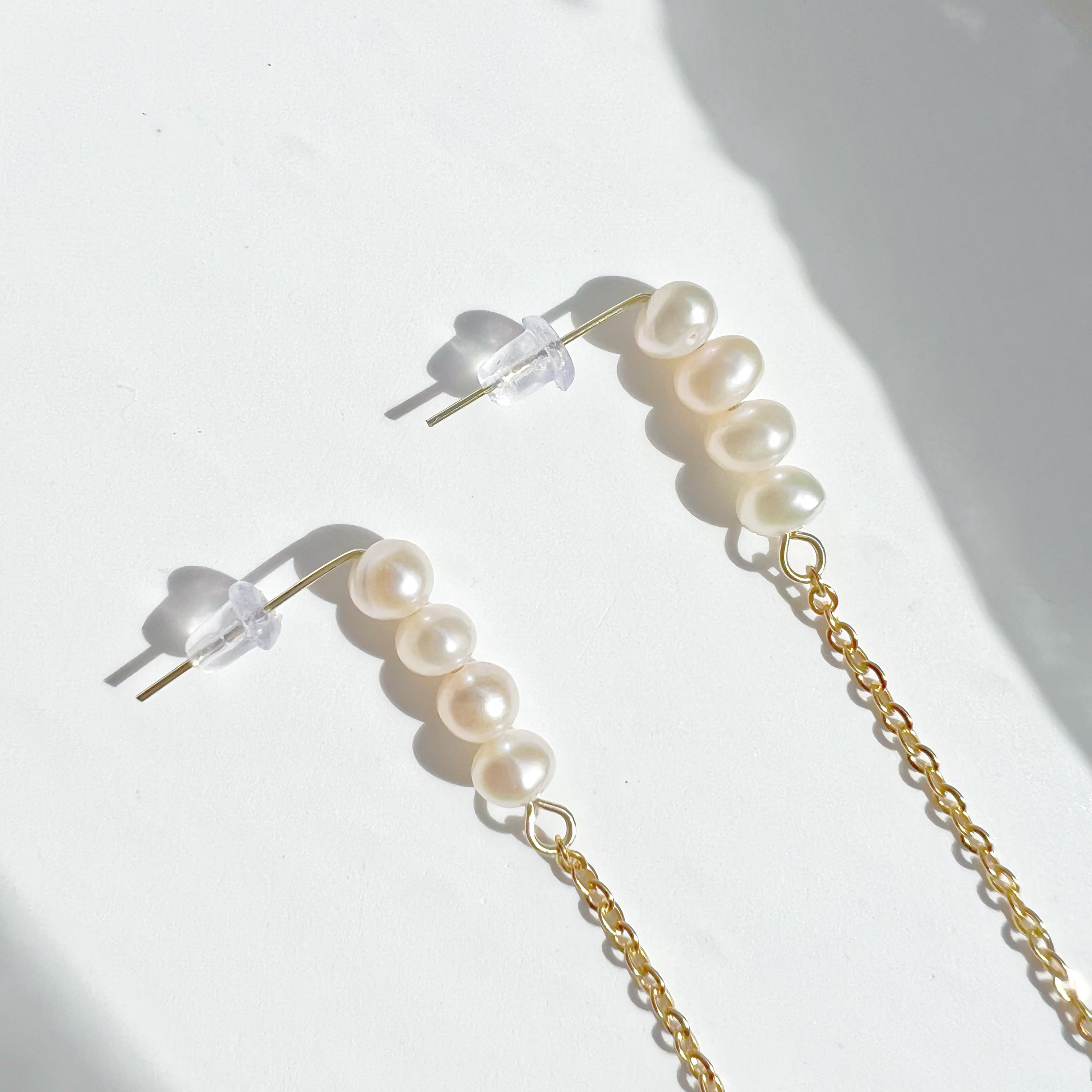 Elegant pink pearl long drop earrings with gold-plated studs, showcasing unique freshwater baroque pearls.