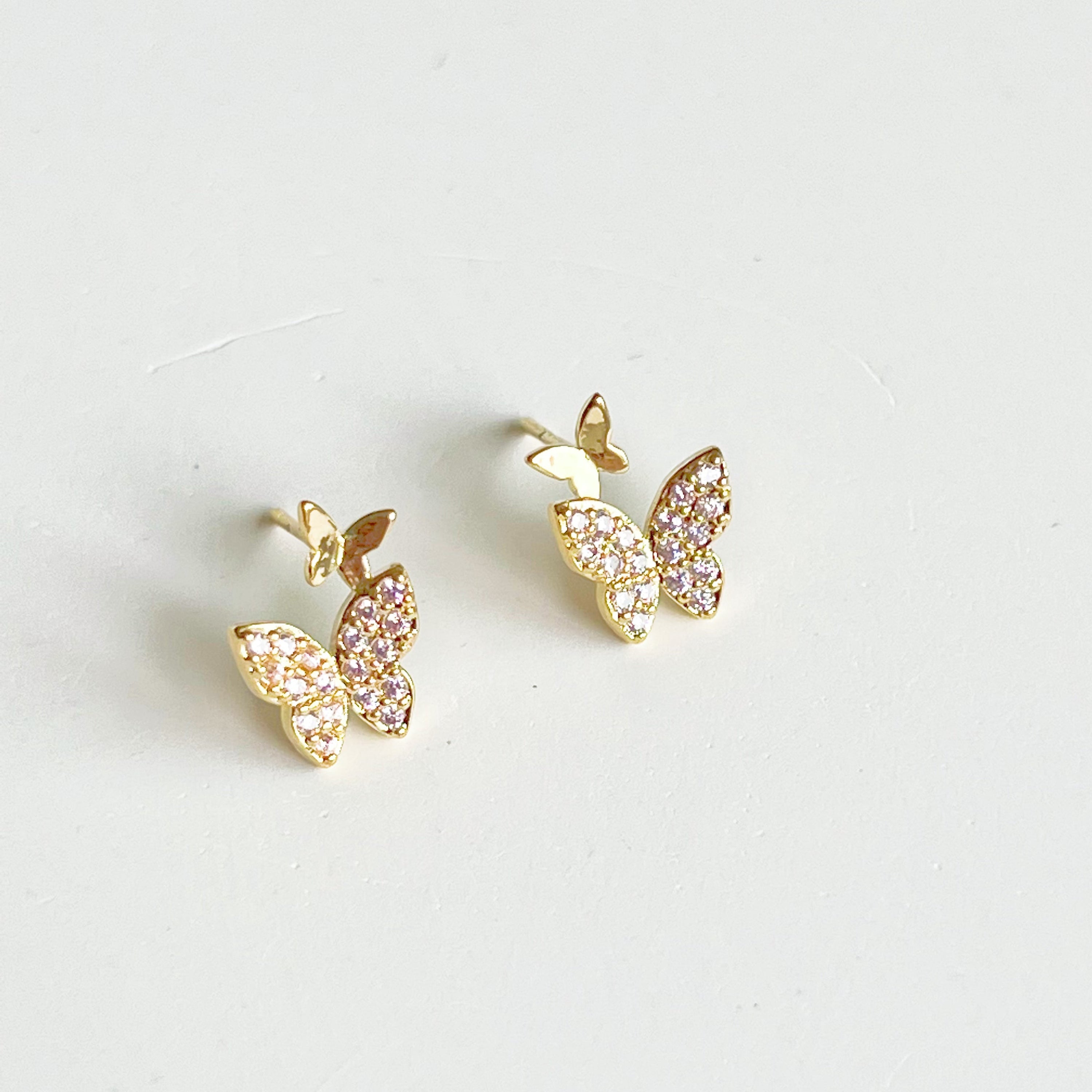 A pair of elegant pink zircon butterflies earrings made from gold-plated sterling silver and bronze, showcasing intricate design and sparkling stones.