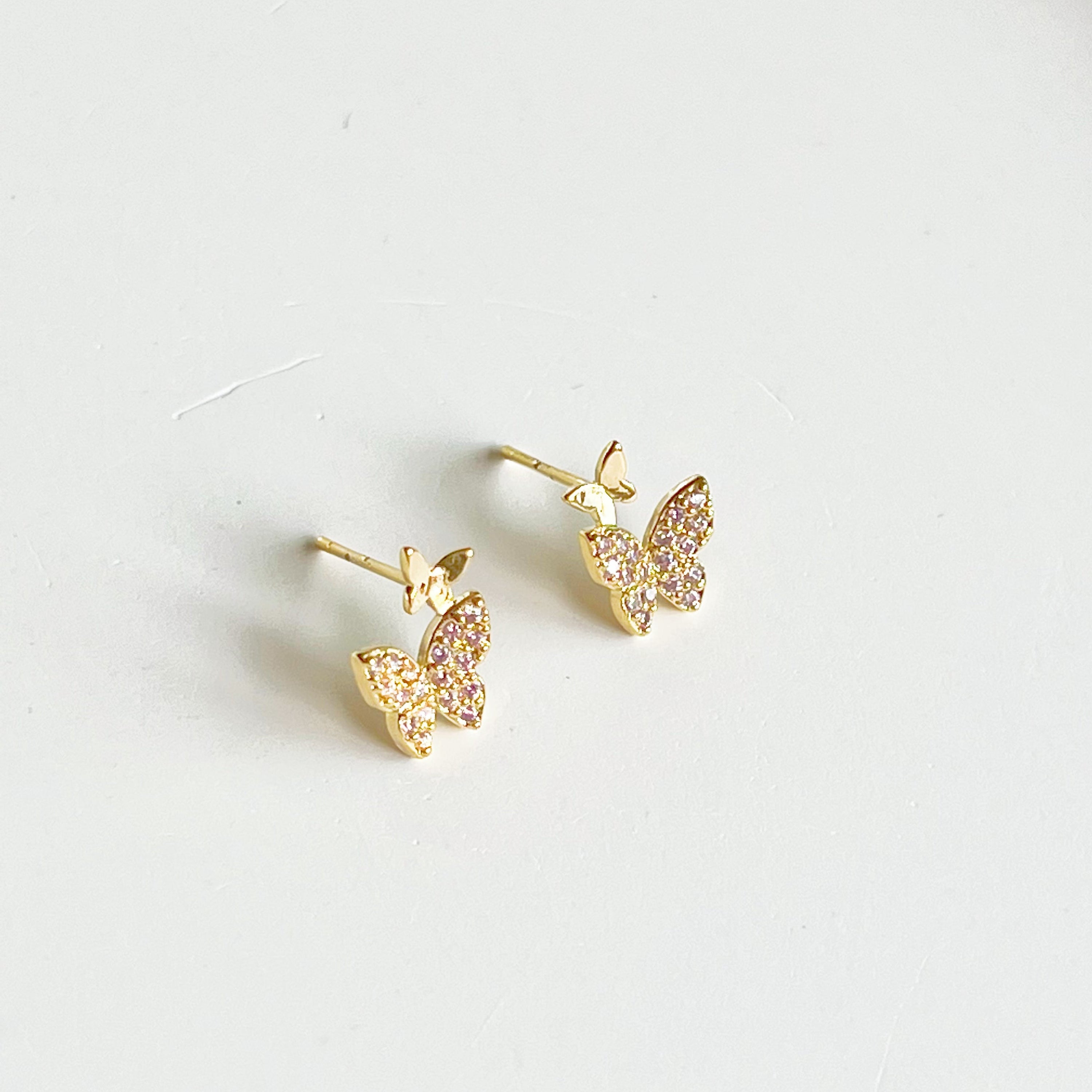 A pair of elegant pink zircon butterflies earrings made from gold-plated sterling silver and bronze, showcasing intricate design and sparkling stones.