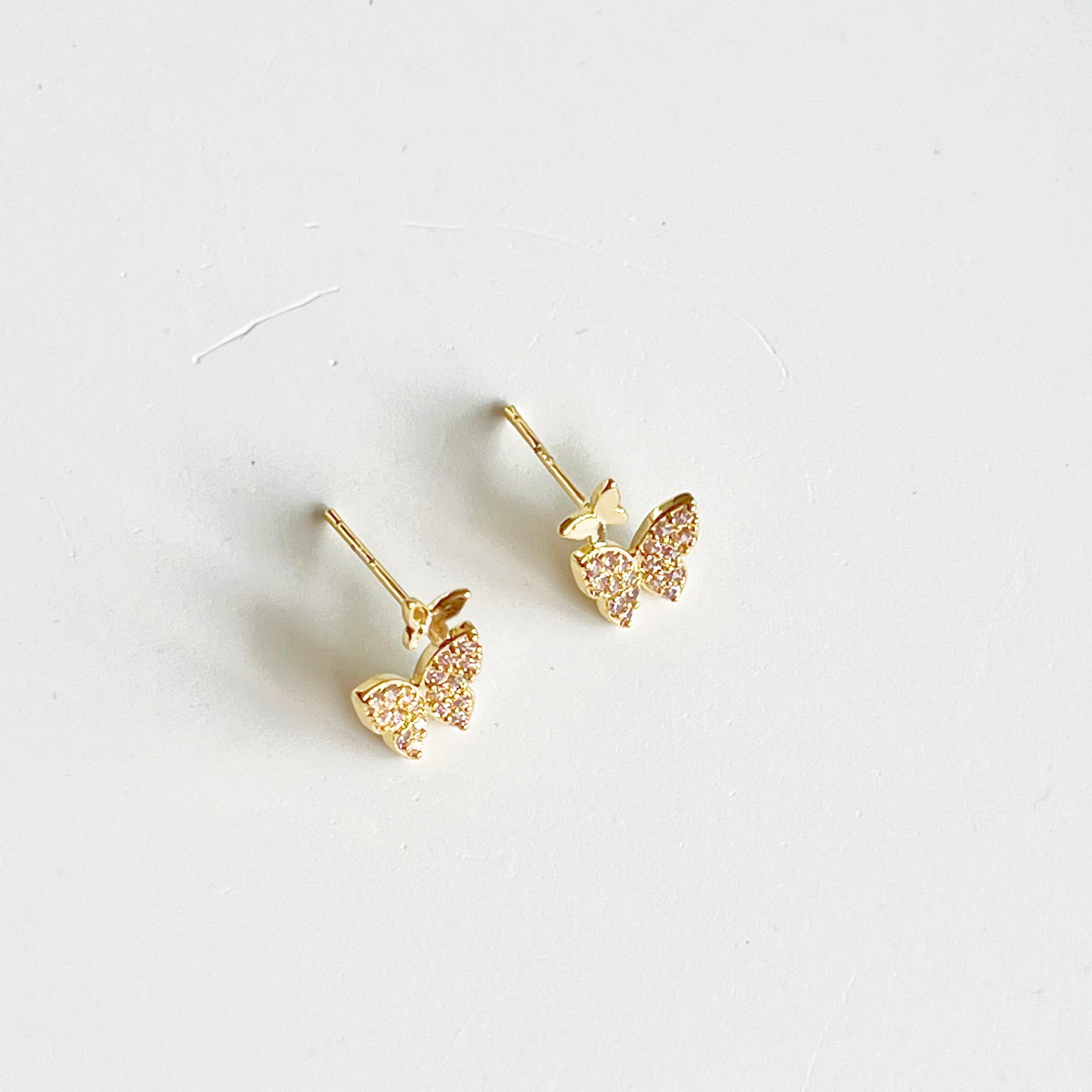 A pair of elegant pink zircon butterflies earrings made from gold-plated sterling silver and bronze, showcasing intricate design and sparkling stones.